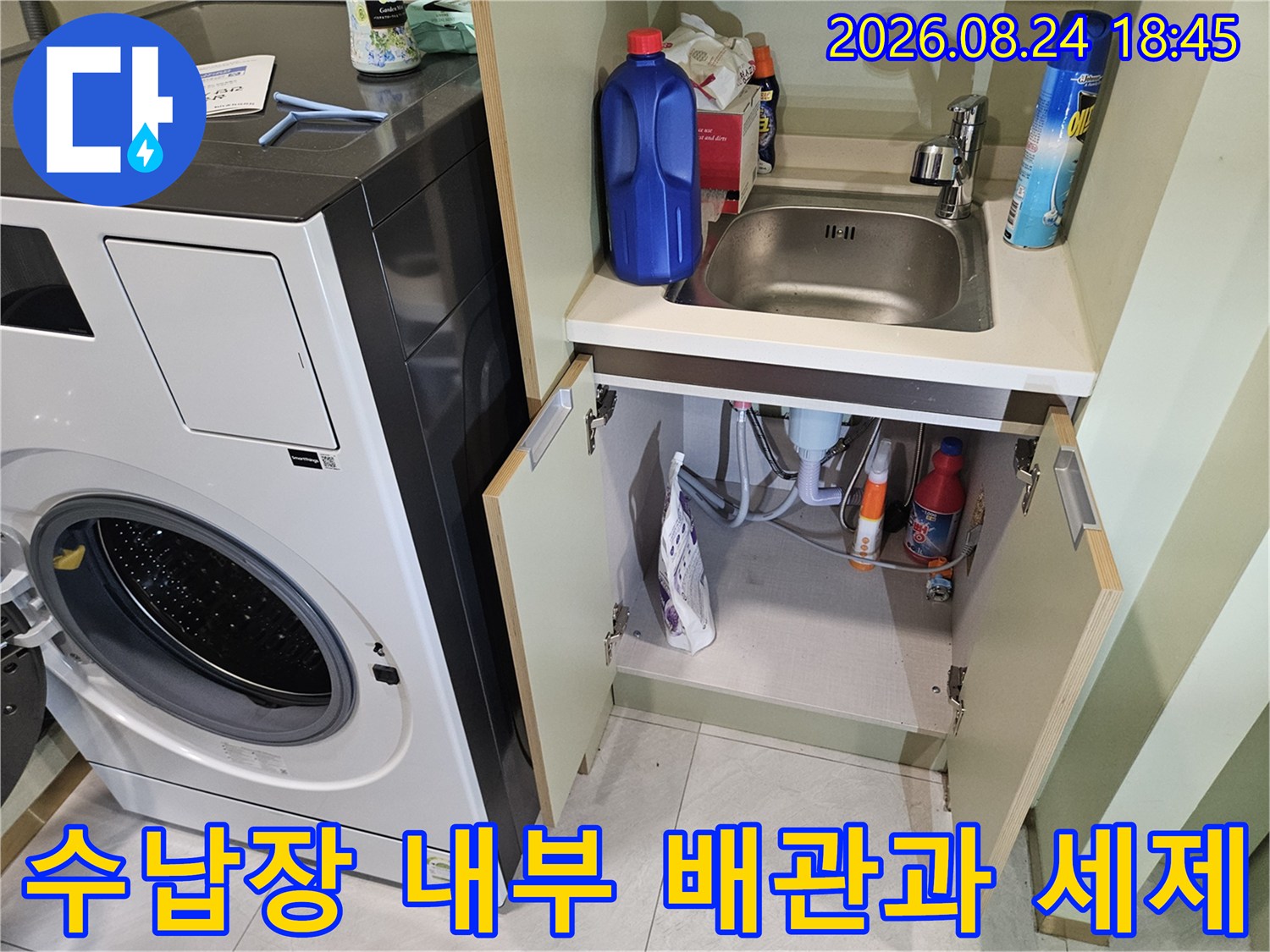 세탁기 수납함 내부에 놓인 세정제와 연결된 배수 호스