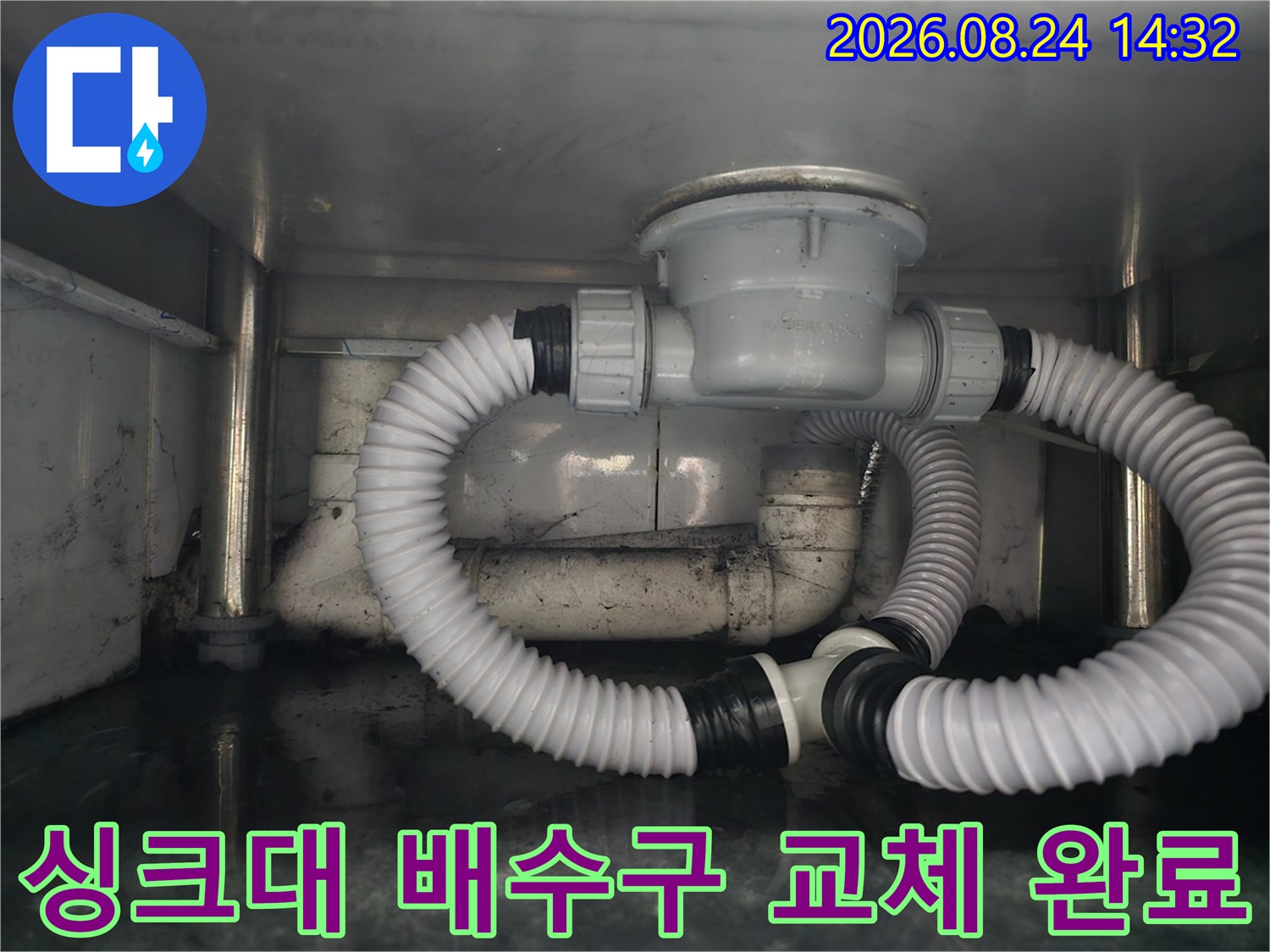 새로 설치된 싱크대 배수통과 굴곡진 호스의 연결 상태를 보여줍니다.