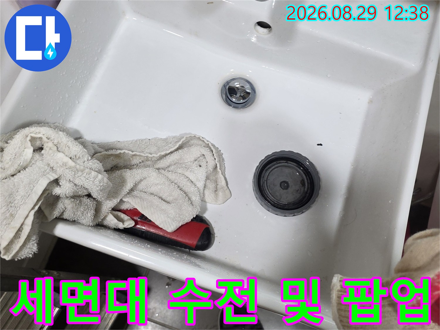 세면대 상단부의 수전과 배수 팝업 장치를 보여주는 사진입니다.