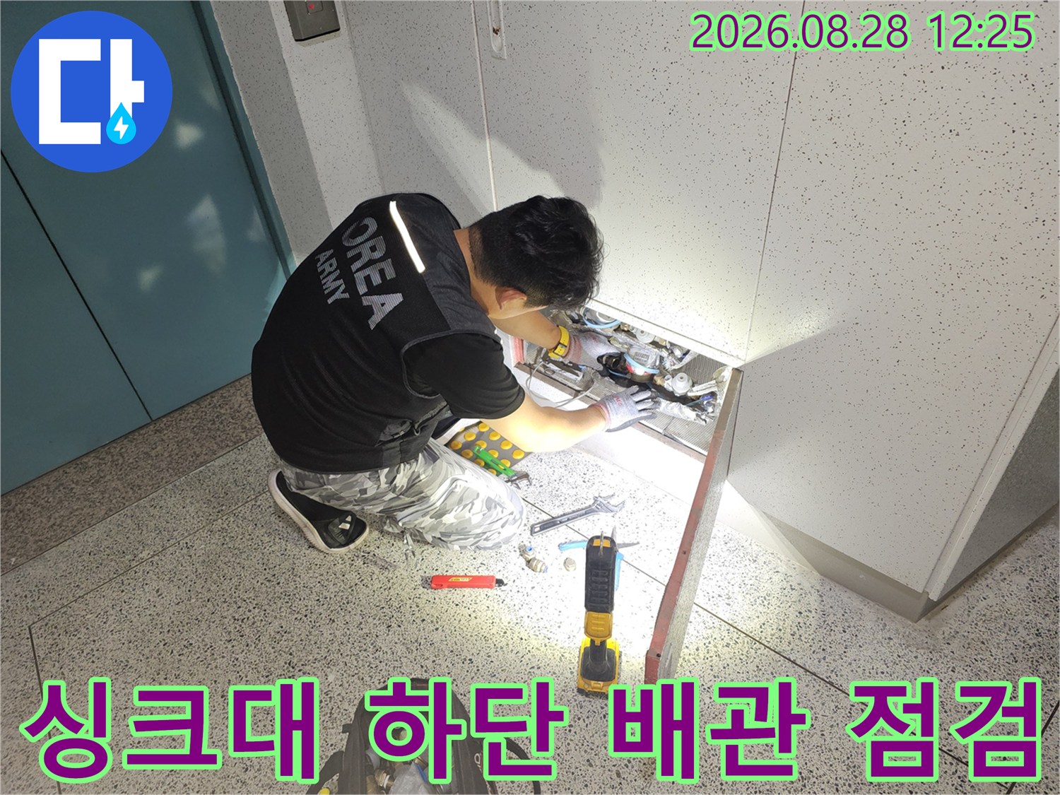 좁은 싱크대 하부 공간에서 진행 중인 배관 정밀 검사 모습입니다.