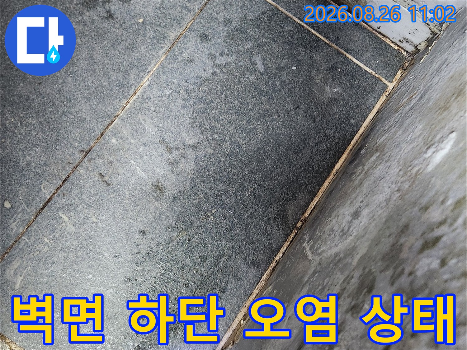 습기가 침투하여 얼룩진 벽면과 타일 경계 부위