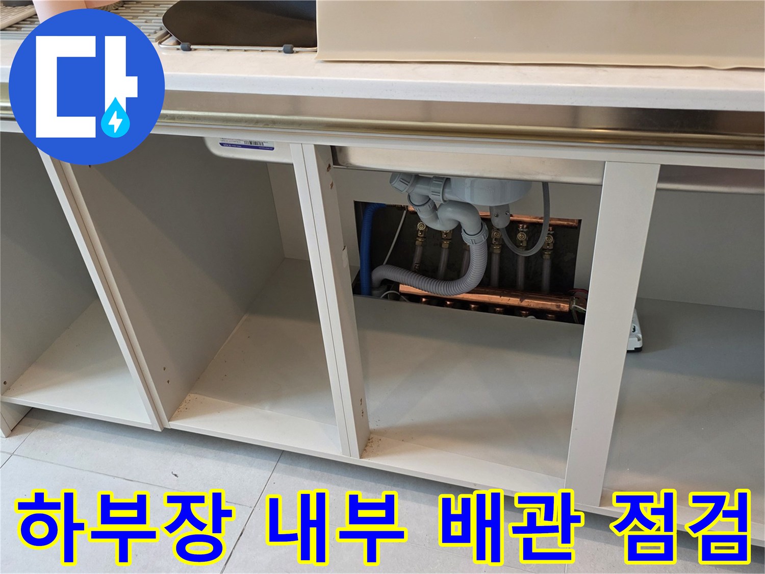 싱크대 밑-배관 연결 부위를 정밀하게 관찰하고 있는 모습입니다.