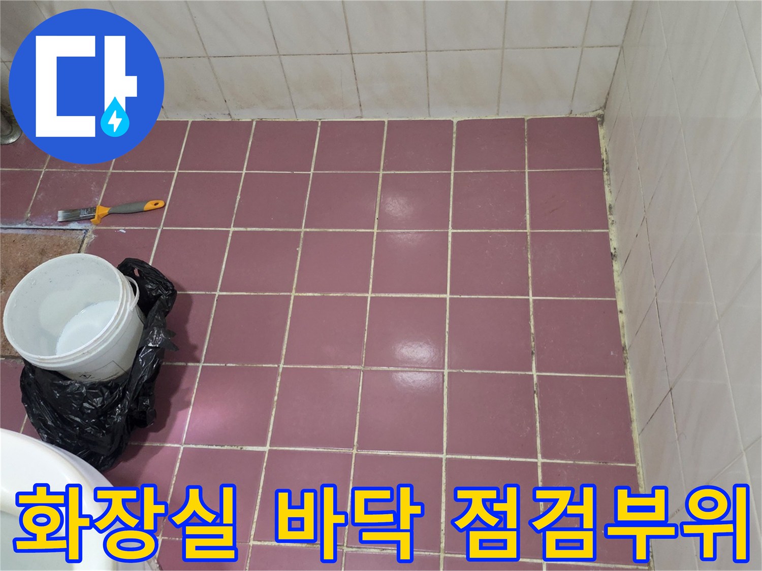분홍색 타일과 작업용 도구가 있는 화장실 내부