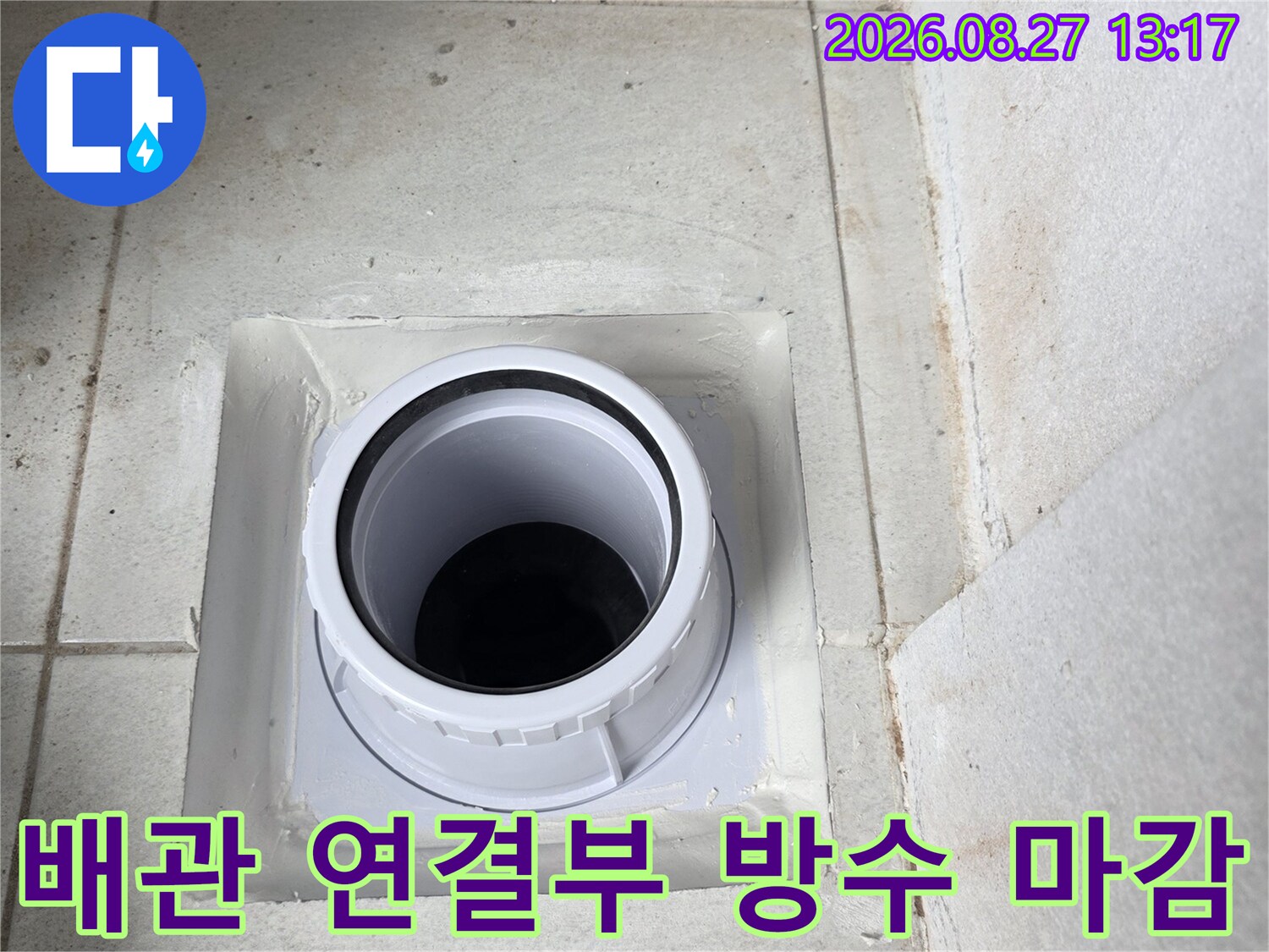 우수관 주변의 하얀색 마감재와 새 배관의 결합 상태를 보여줍니다.