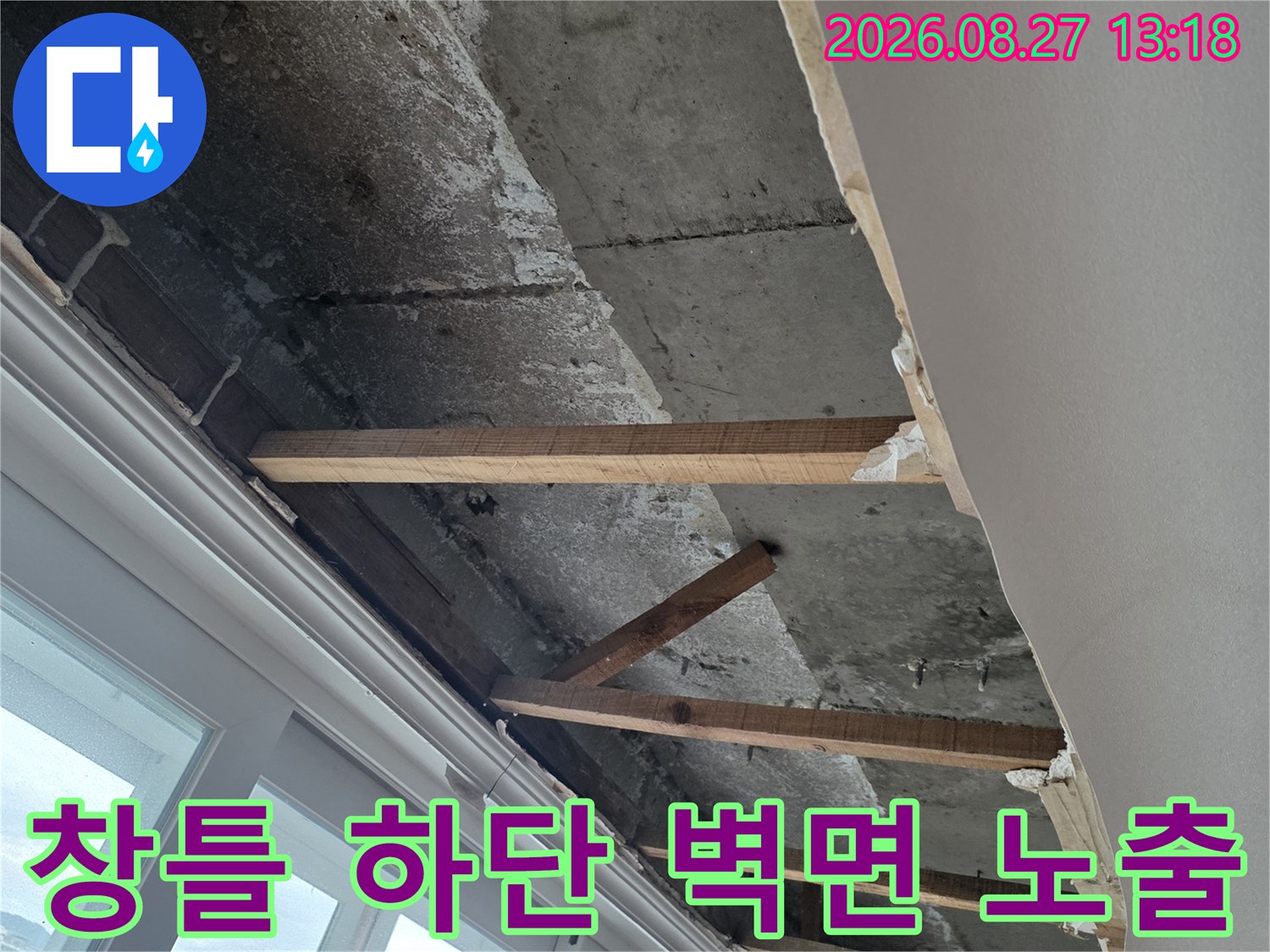 창문 아래쪽-노출된 콘크리트 벽체와 목재 프레임의 모습