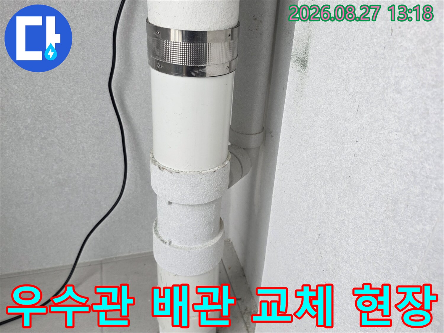 하얀색 우수관과 금속 클램프로 고정된 연결 부위 상세 사진