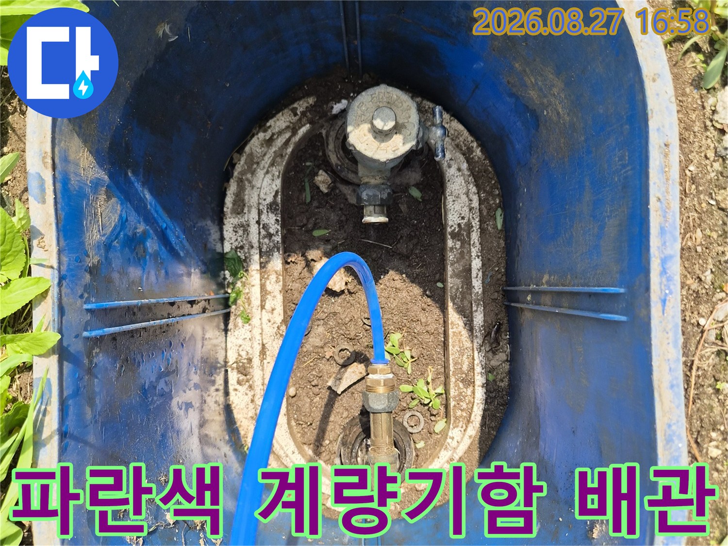 파란색 플라스틱 계량기함 내부의 수도 밸브와 연결 배관 모습