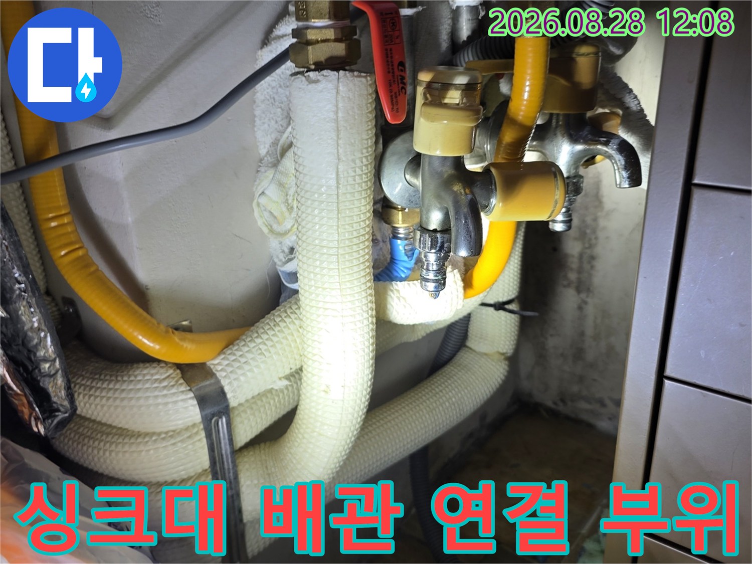 노란색 호스와 흰색 보온재가 함께 있는 싱크대 하부 배관 구조