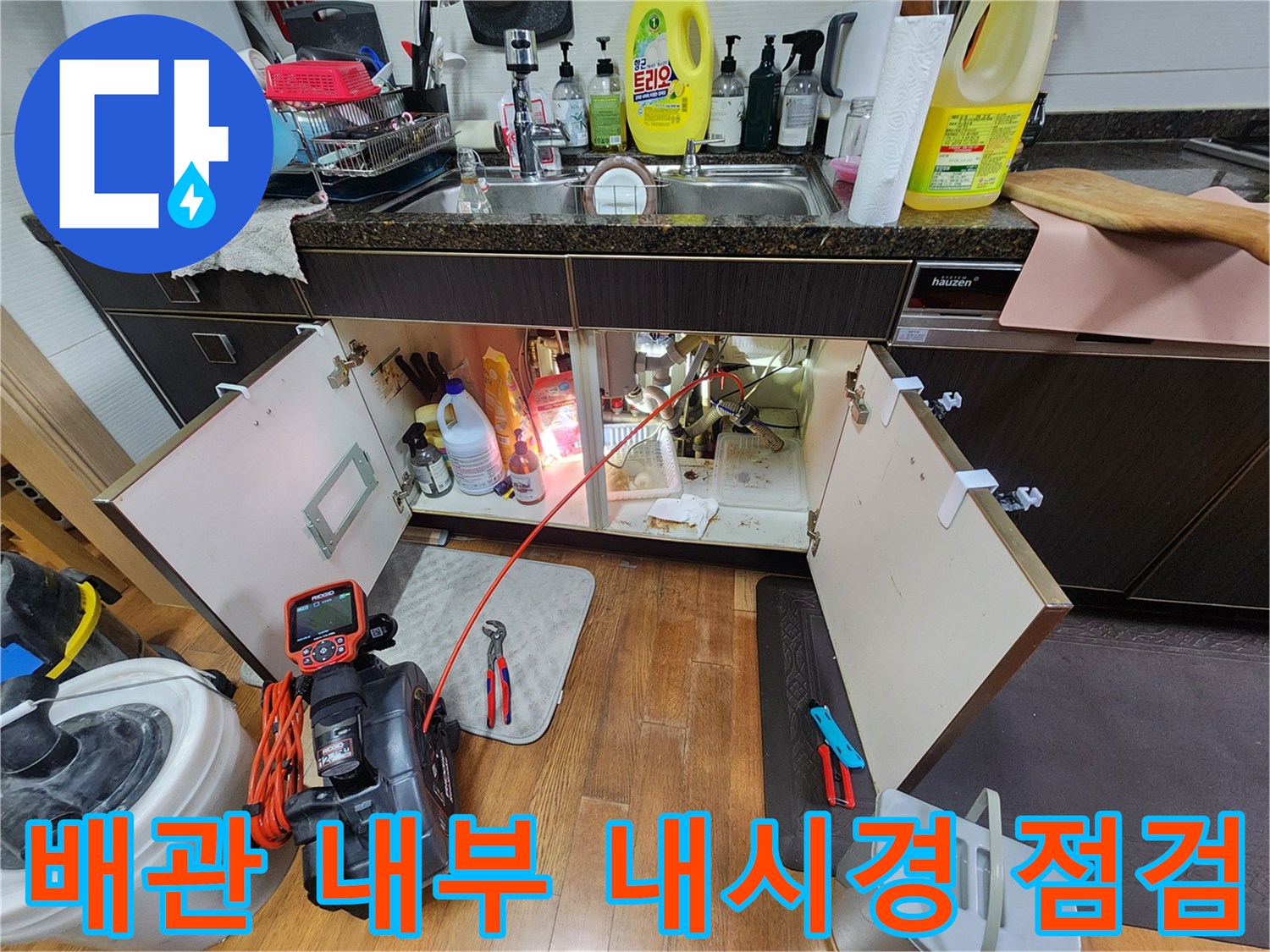 싱크대 하단 배수구에 내시경 장비를 삽입하는 작업 모습