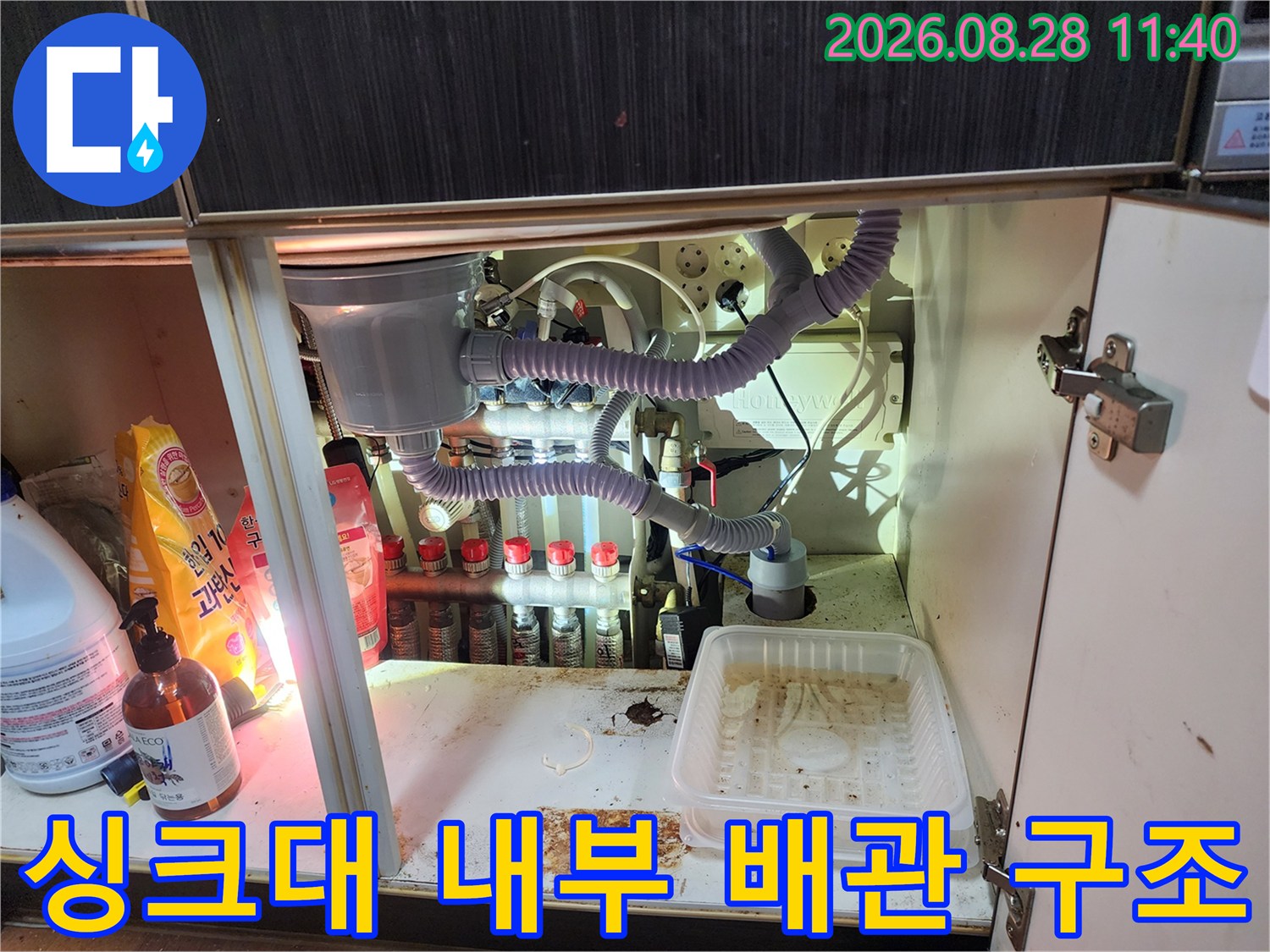 싱크대 하부장에 설치된 정수기 필터와 연결된 여러 갈래의 배관들