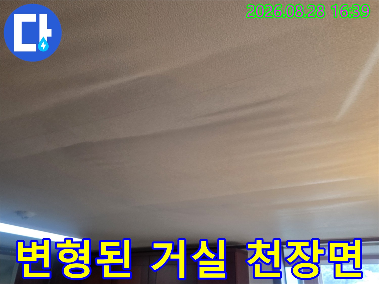 수분 유입으로 인해 아래로 처지고 굴곡진 거실 천장 사진입니다.