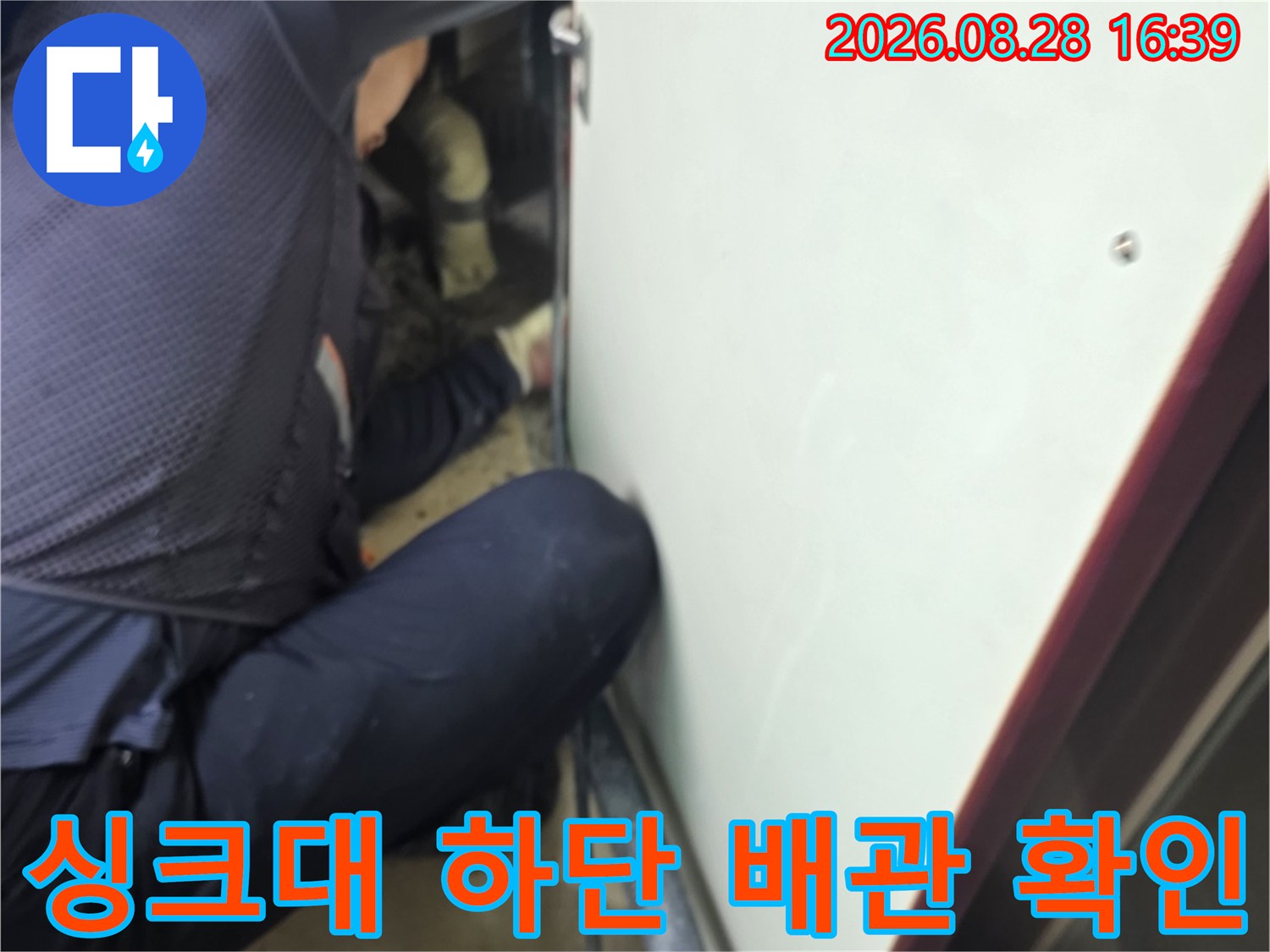 싱크대 밑 공간에서 진행 중인 배관 누수 여부 정밀 점검 작업