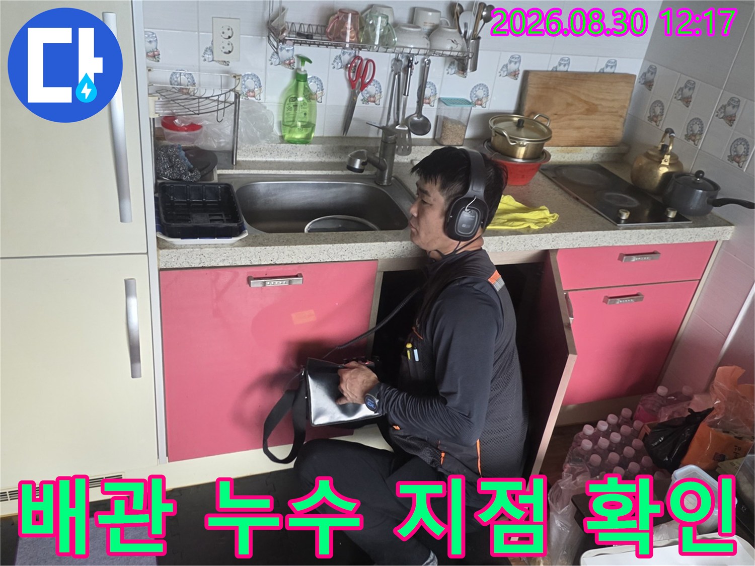 싱크대 밑 배관의 미세한 누수를 찾기 위해 탐지기를 사용하고 있습니다.