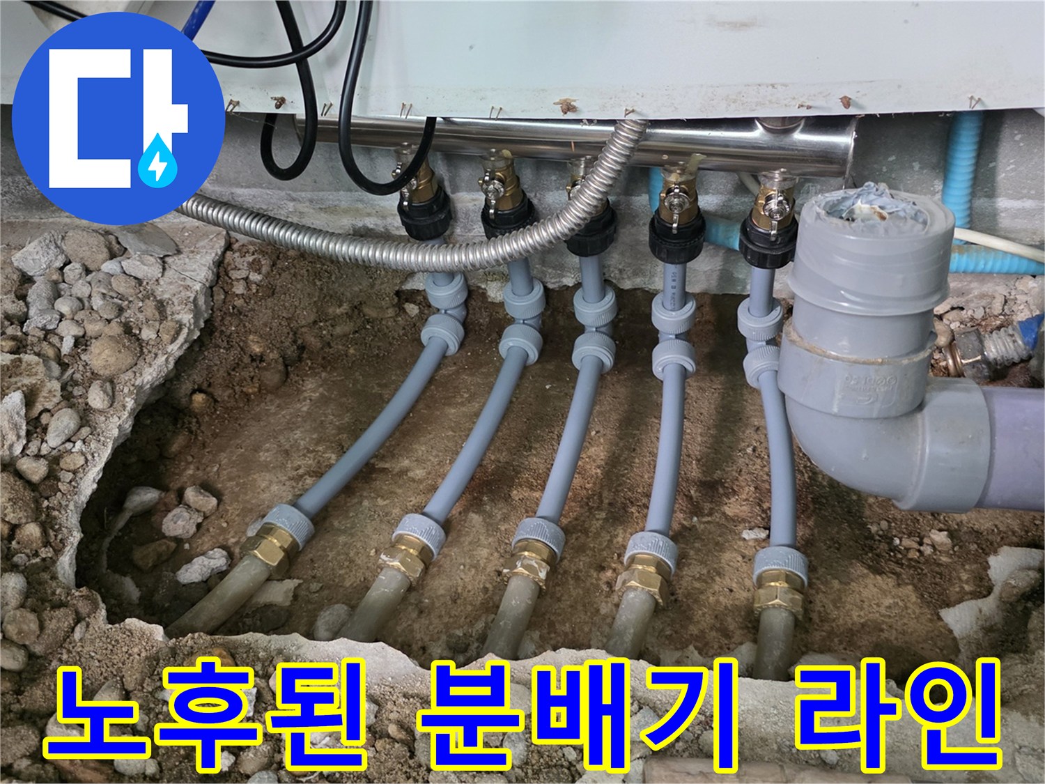 싱크대 아래 흙과 자갈 속에 노출된 배관 연결 부위