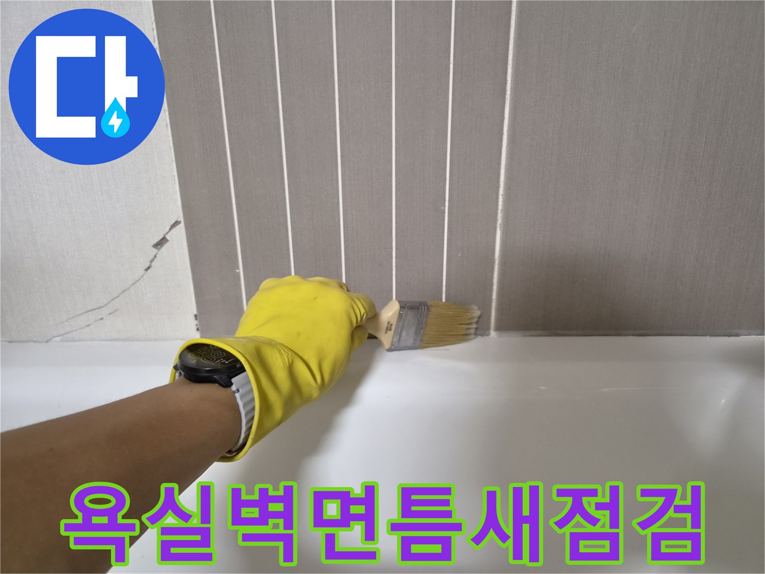 노란색장갑을_낀_작업자가_붓으로_욕조와_벽면_사이의_틈새를_살피는_모습