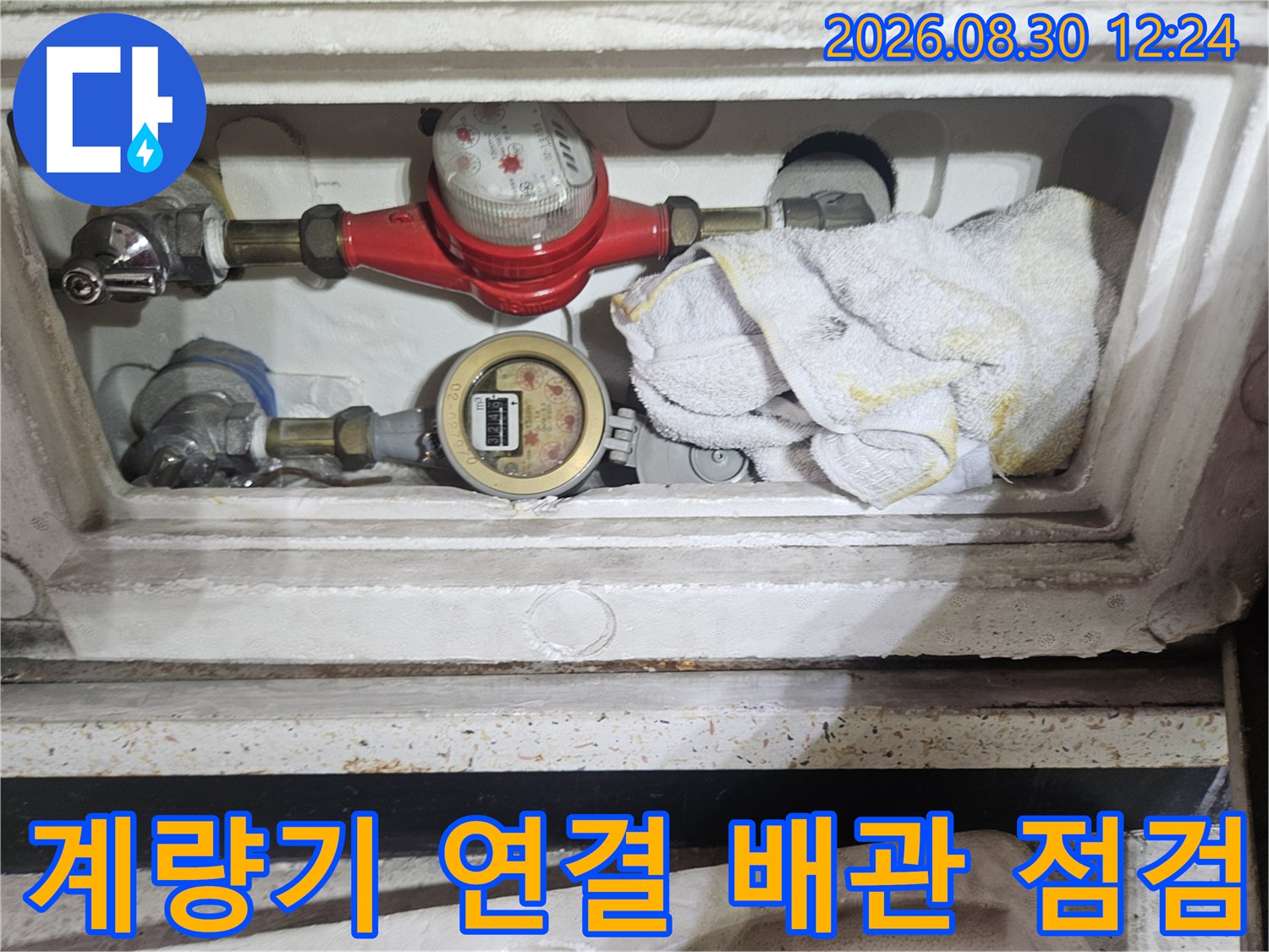 수도 계량기함 내부의 밸브와 연결된 금속 배관들을 상세히 촬영하였습니다.