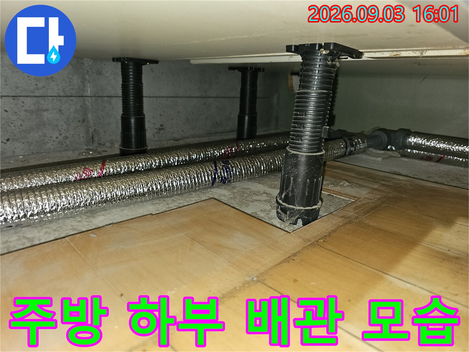 싱크대 아래쪽 은색 보온재 배관과 검은색 지지 기둥의 배치