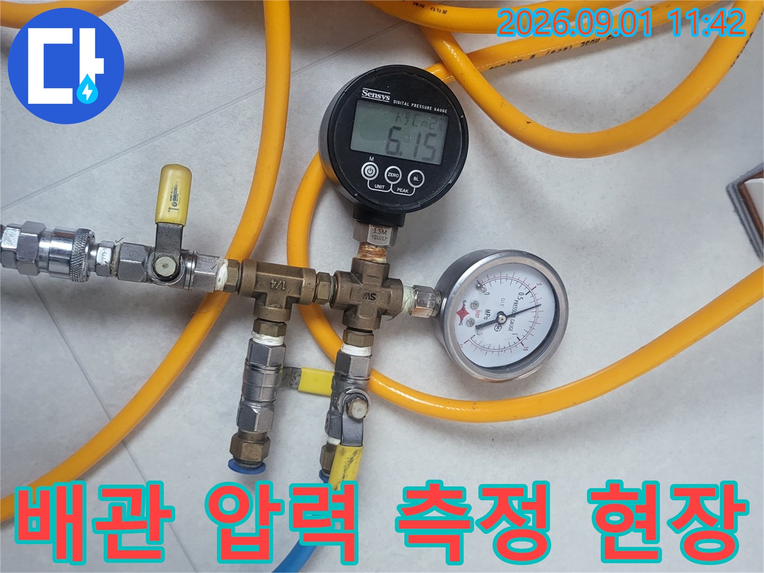 노란색 호스와 연결된 배관 압력 측정 장비의 상세 모습