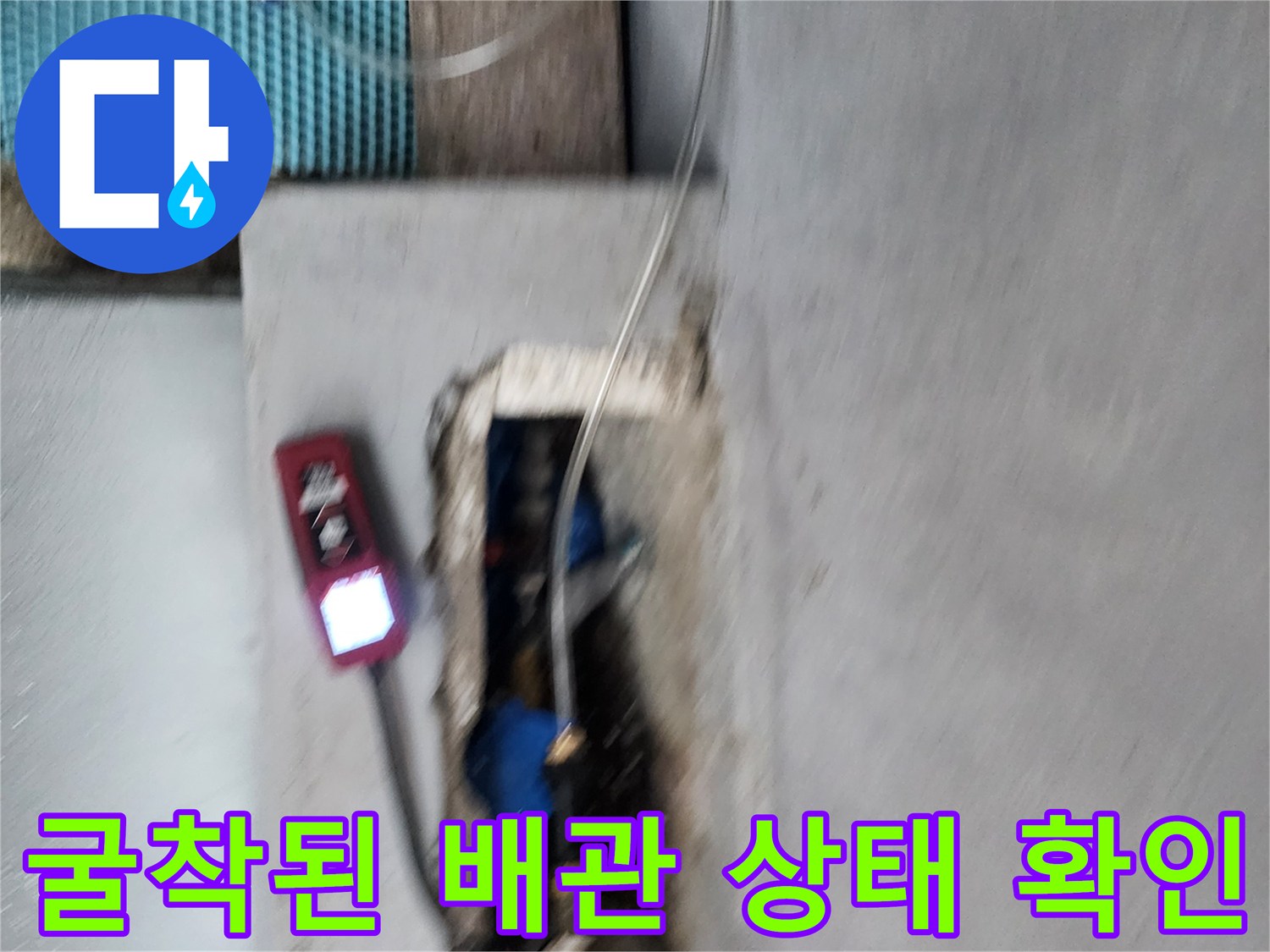 노출된 수도 배관에-탐지 장비를 연결하여 점검하는 장면