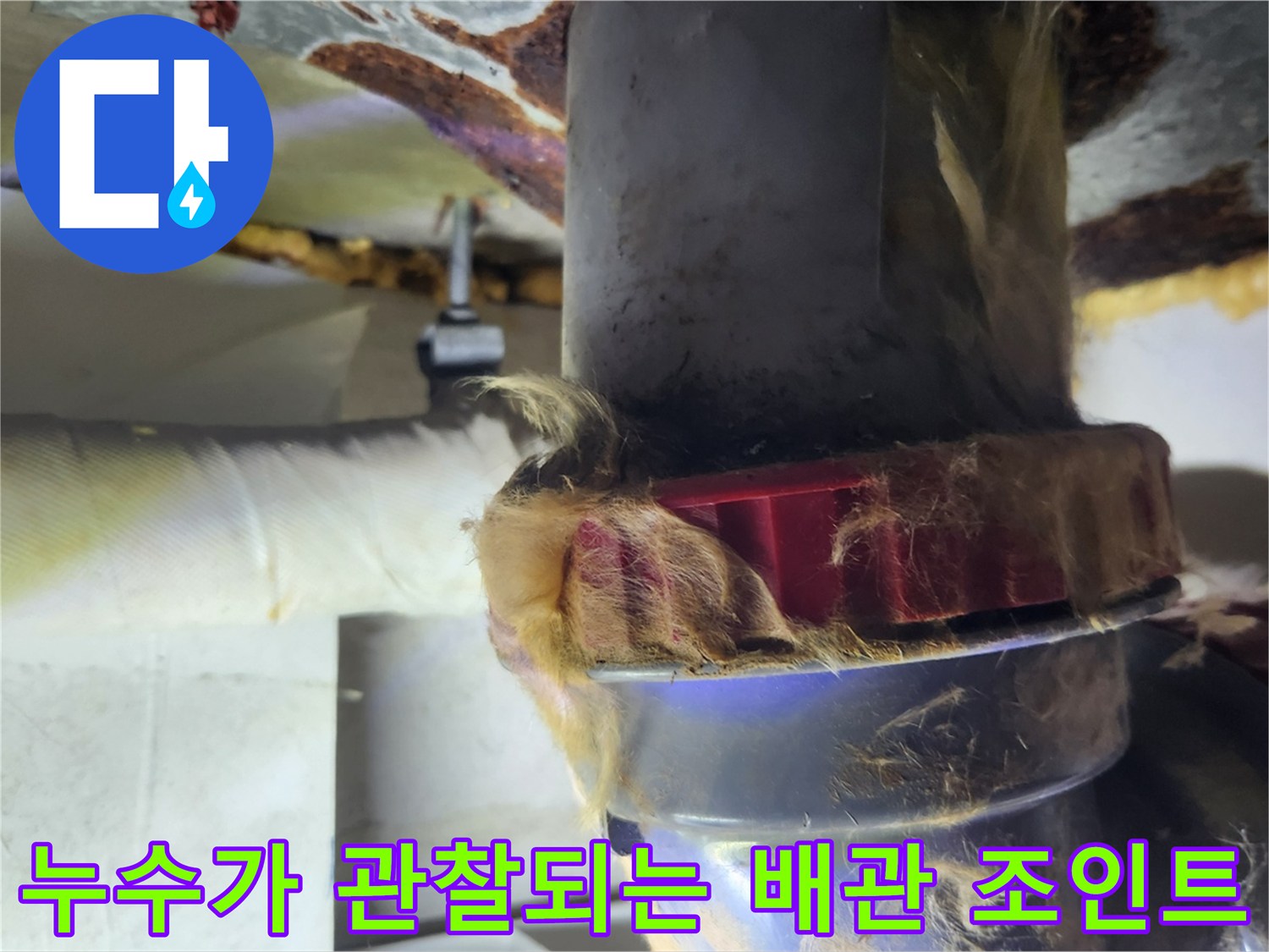 습기가 침투한 배수관 보온재와 붉은색 너트 연결 부위 사진입니다.