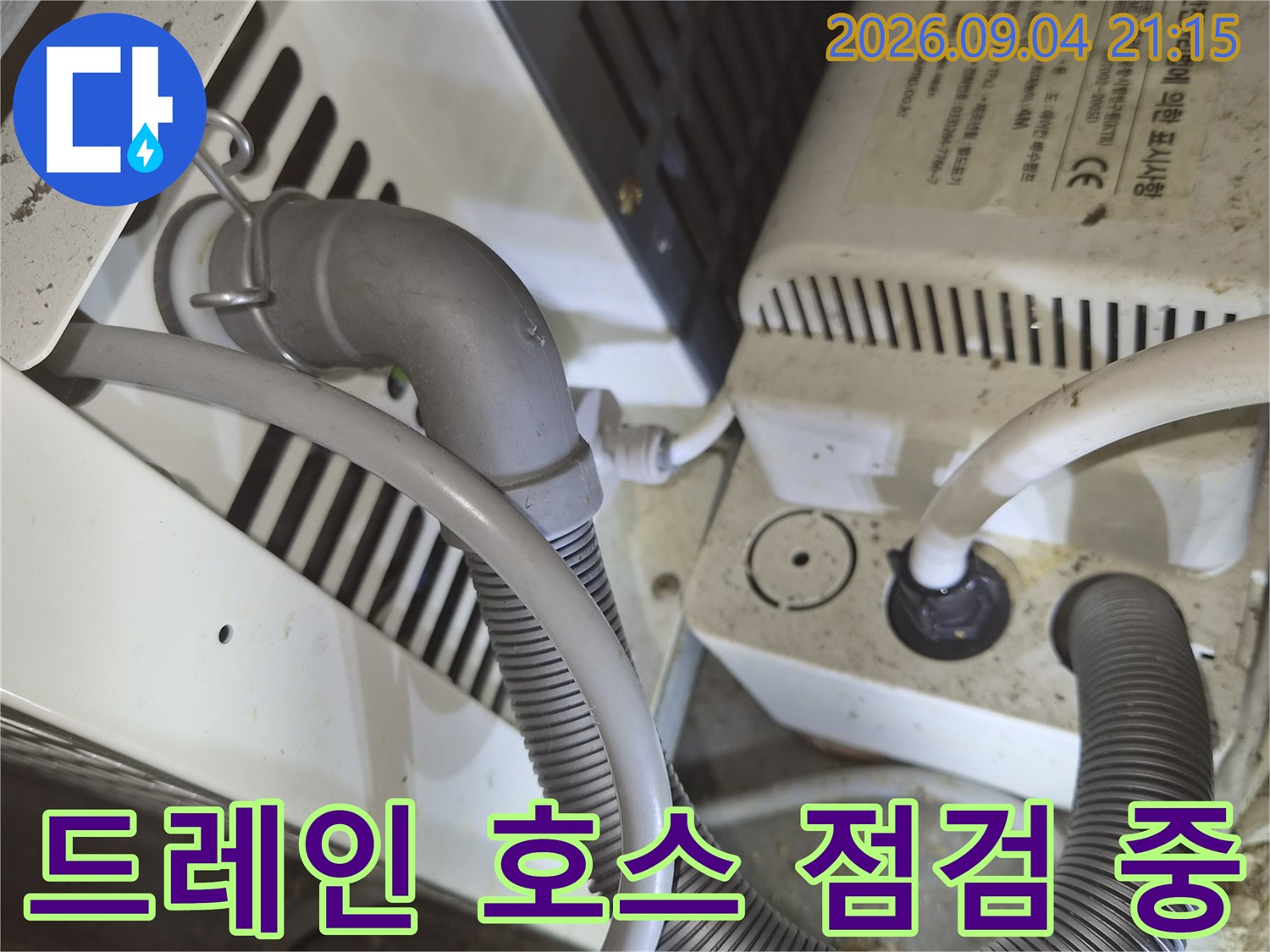 에어컨 드레인 배관의 굴곡진 호스와 연결 장치를 촬영하였습니다.