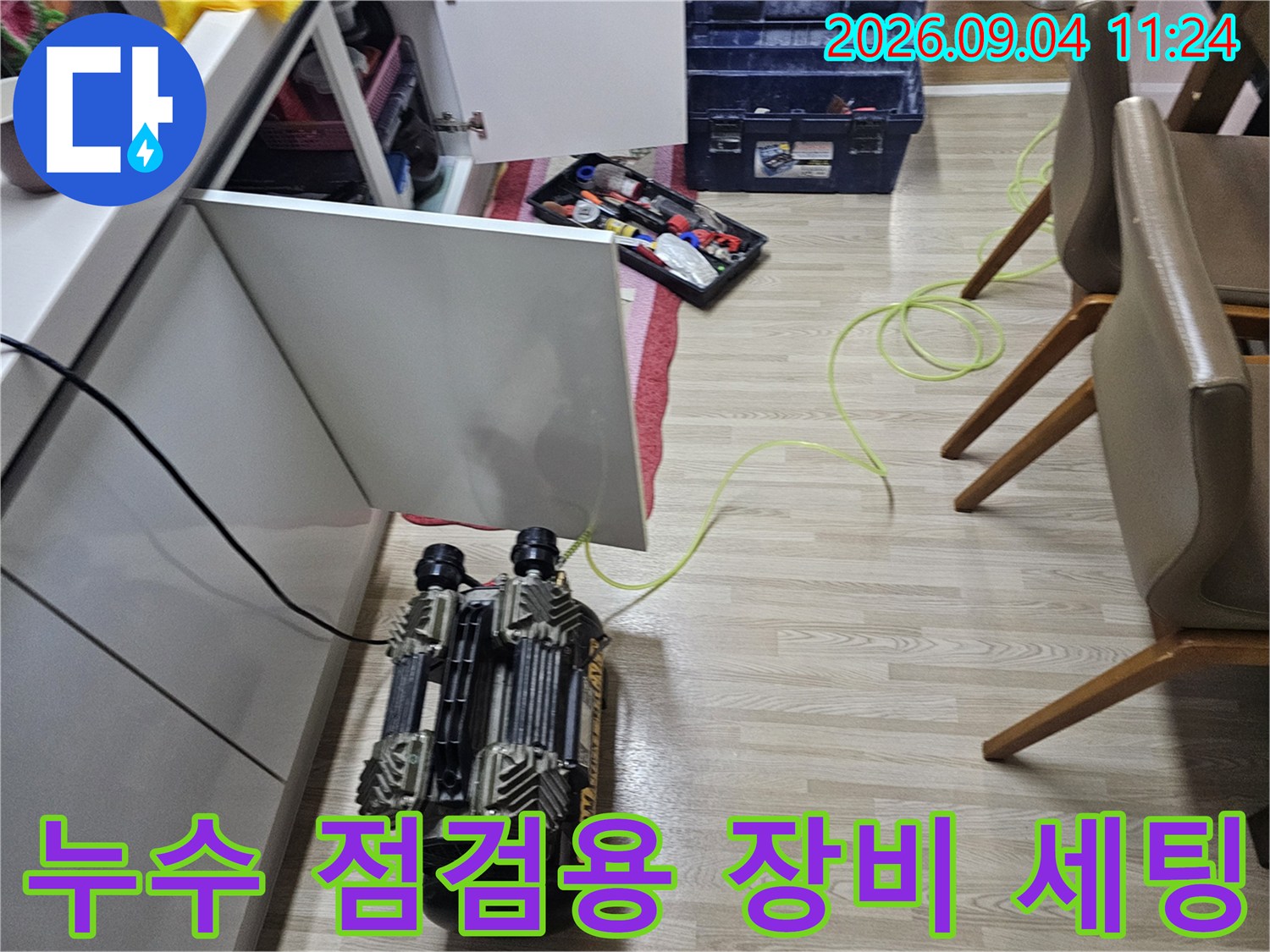보일러실 바닥에서-누수 진단을 위해 준비된 공압 테스트 장비와 공구함