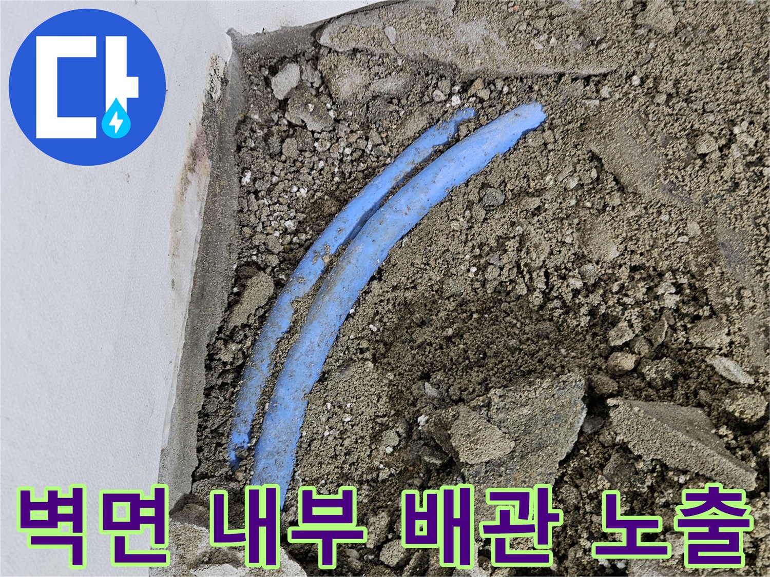 콘크리트-조각들-사이의-파란색-배관-노출