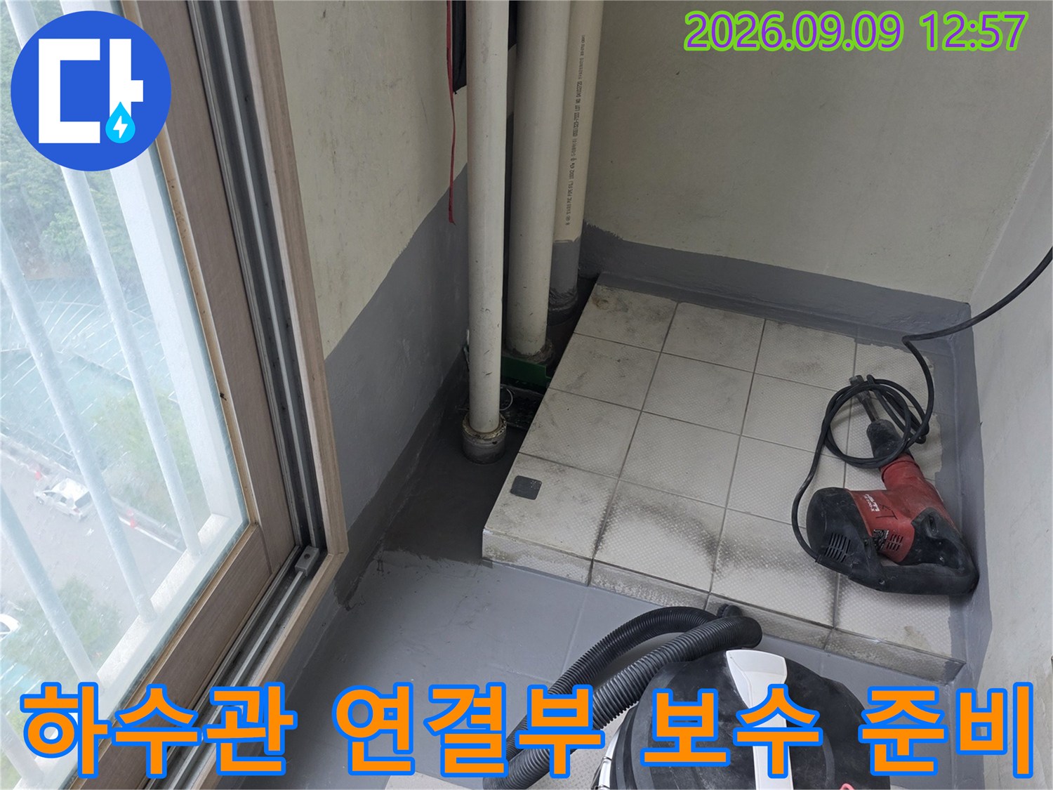 공사 현장의 배수관과 작업용 전동 드릴 및 청소기