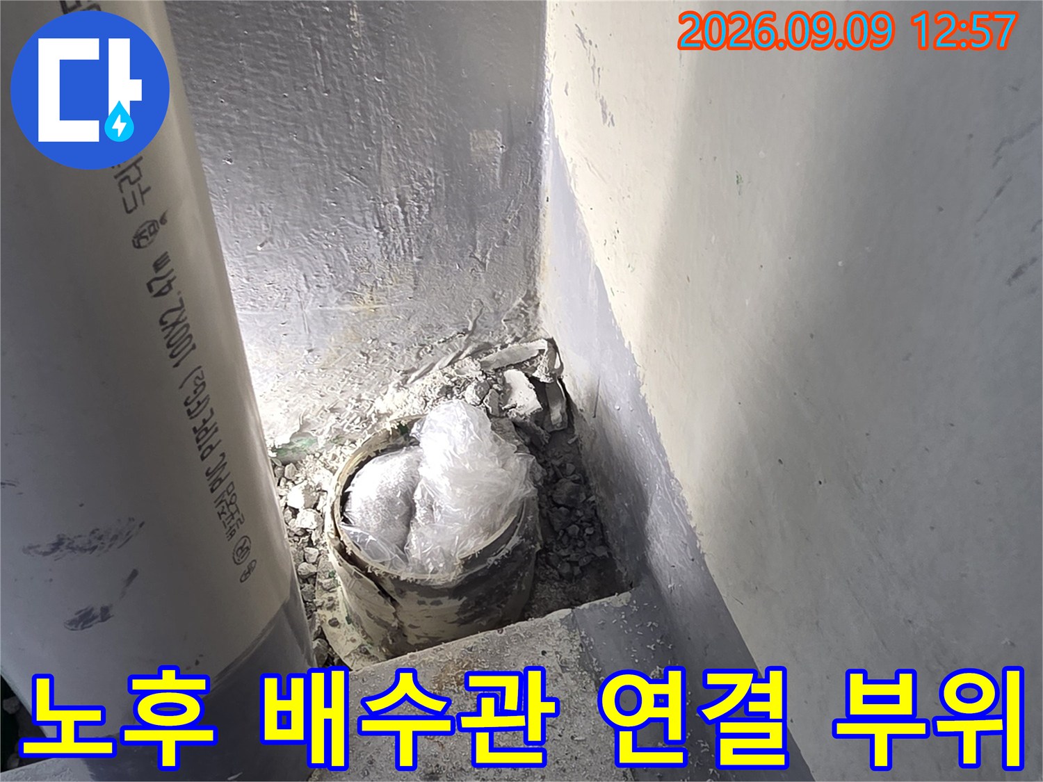 다용도실 배수관의 노후된 연결 지점과 틈새를 근접 촬영한 이미지