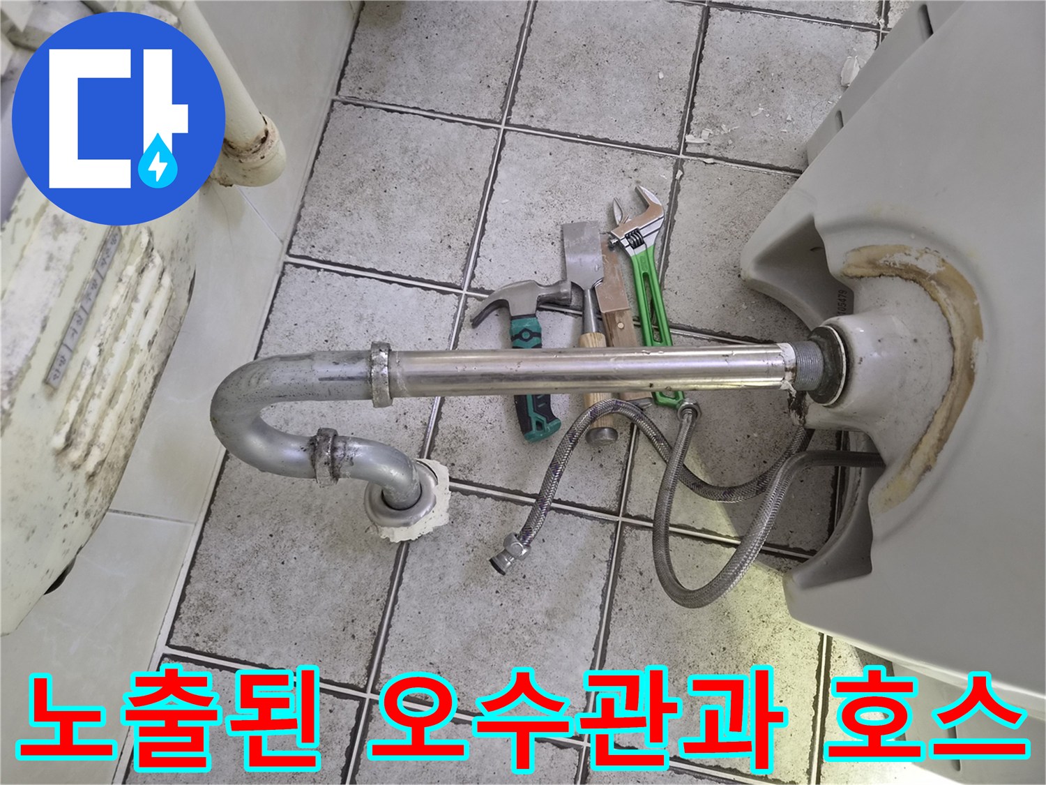 바닥 타일 위로 드러난 세면대 배수관과 양변기용 오수관