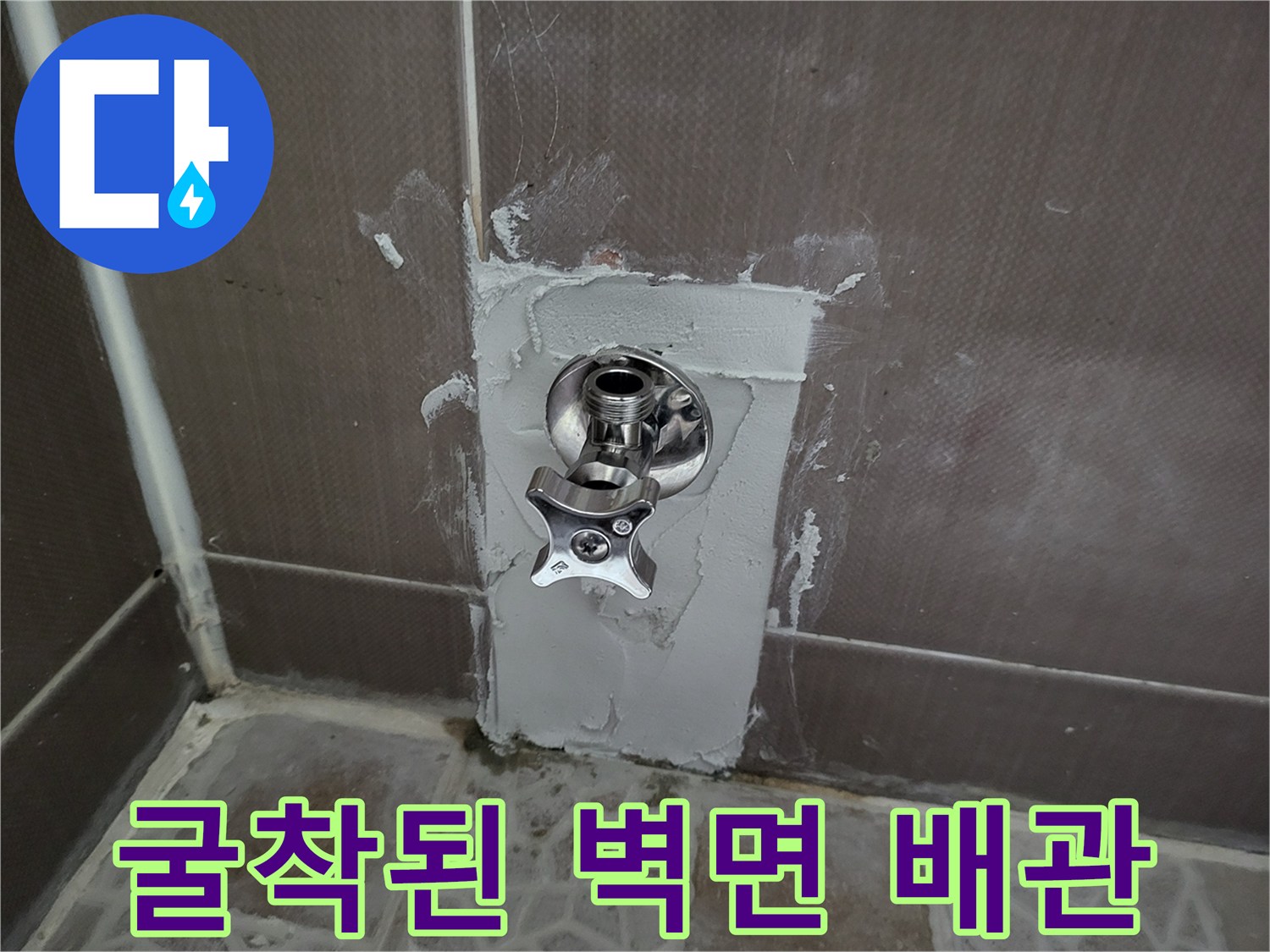 타일을 제거하여 드러난 수도 연결 부위와 미장 작업 흔적