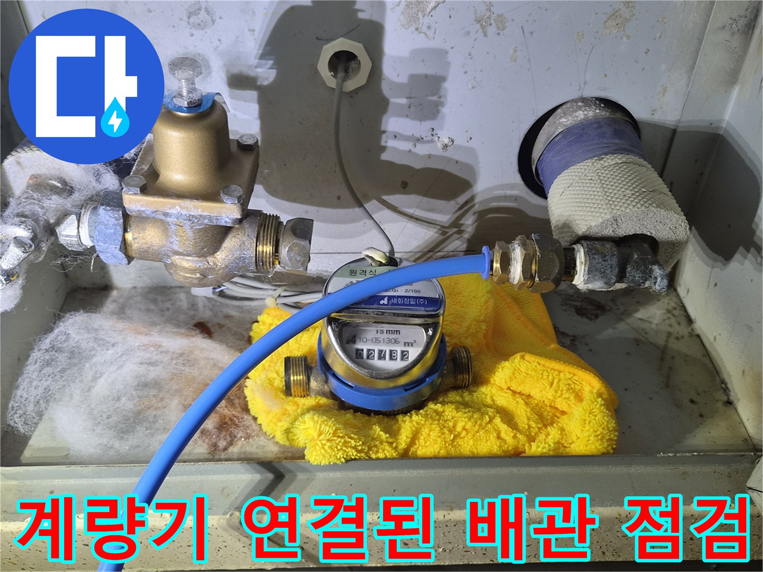 파란색 호스가 연결되어 압력을 측정 중인 수도 계량기 사진입니다.