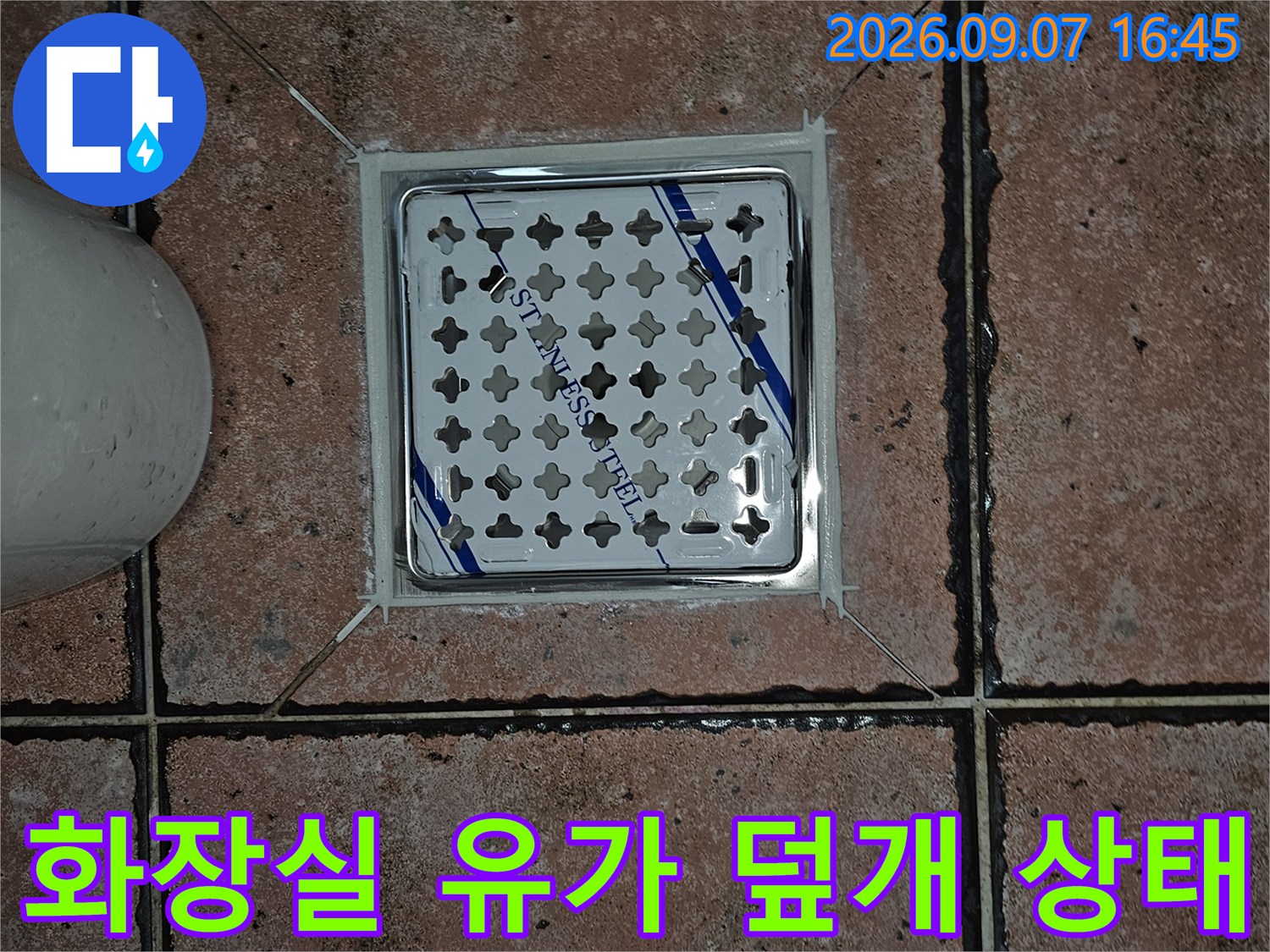 스테인리스 재질의 배수구 덮개와 주변 타일 마감 부위
