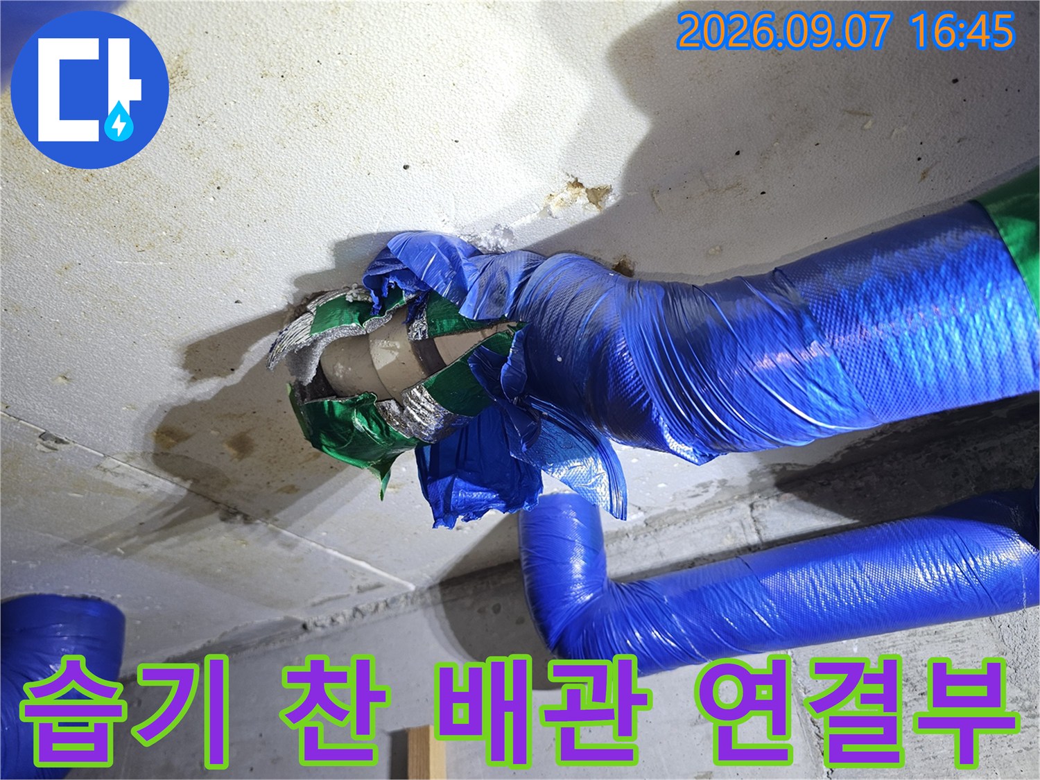 파란색 보온재로 감싸진 배관 주변의 콘크리트 천장 오염 상태를 보여줍니다.