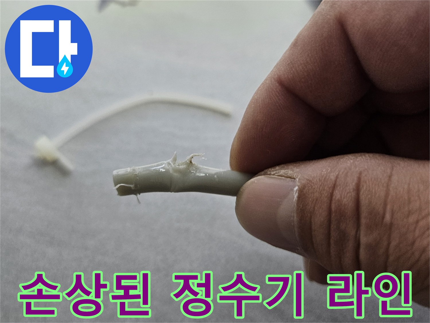 훼손되어 물이 맺혀 있는 하얀색 정수기 호스