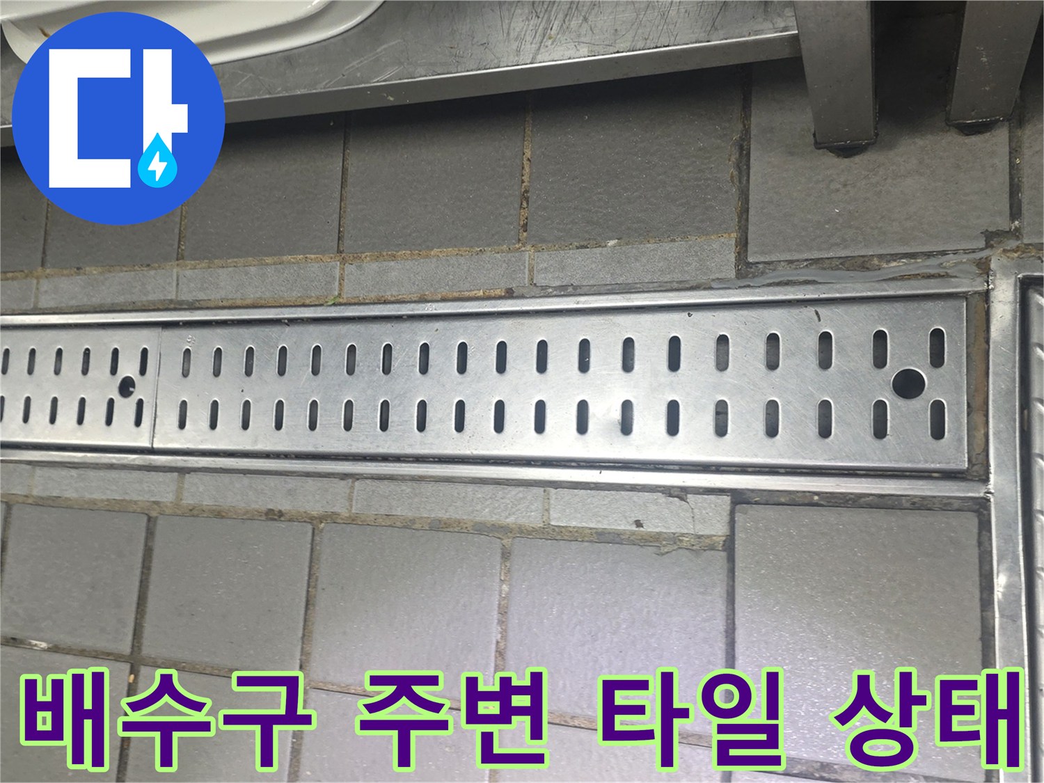 금속 배수 트렌치와 인접한 회색 타일의 접합부 상세 사진