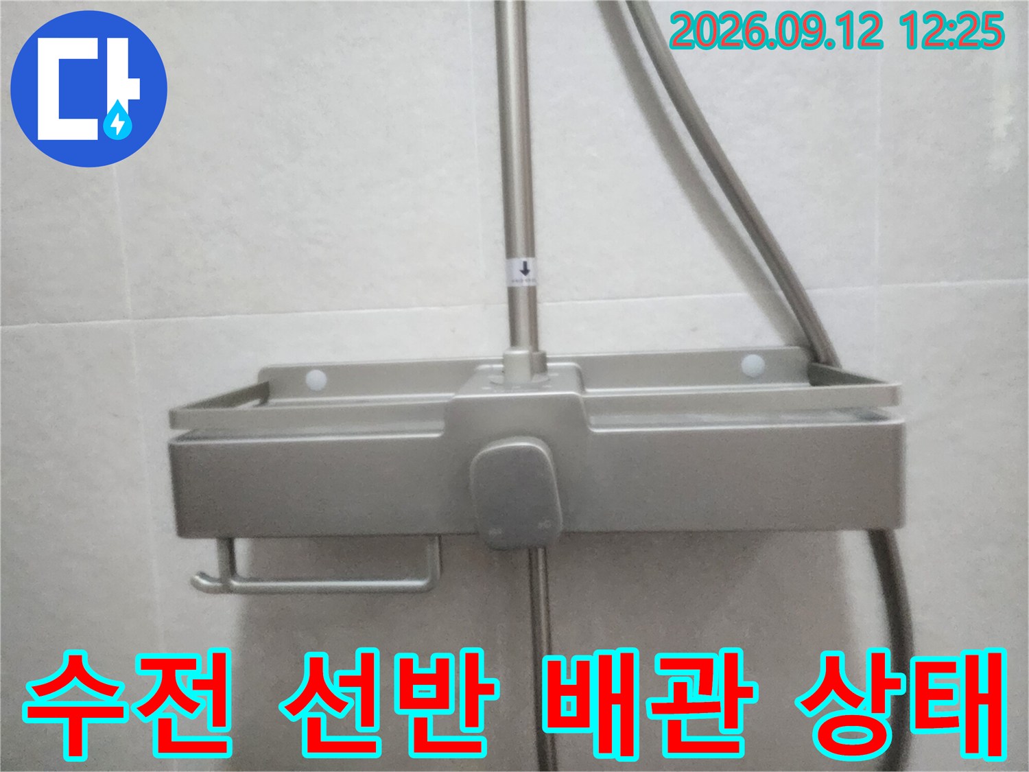 벽면에 설치된 스테인리스 샤워기 선반과 수전 부위입니다.