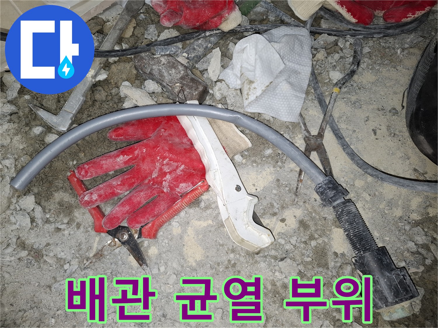파손된 회색 배관과 작업 도구가 있는 현장