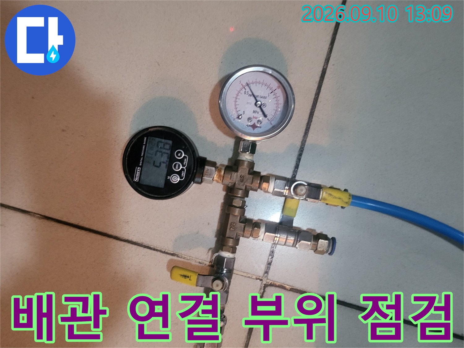 노란색 호스와 파란색 호스가 연결된 배관 점검 장치입니다.