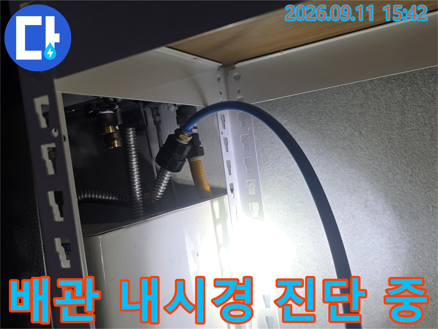 좁은 공간의 배관 구조를 확인하기 위해 내시경 카메라를 투입한 장면입니다.
