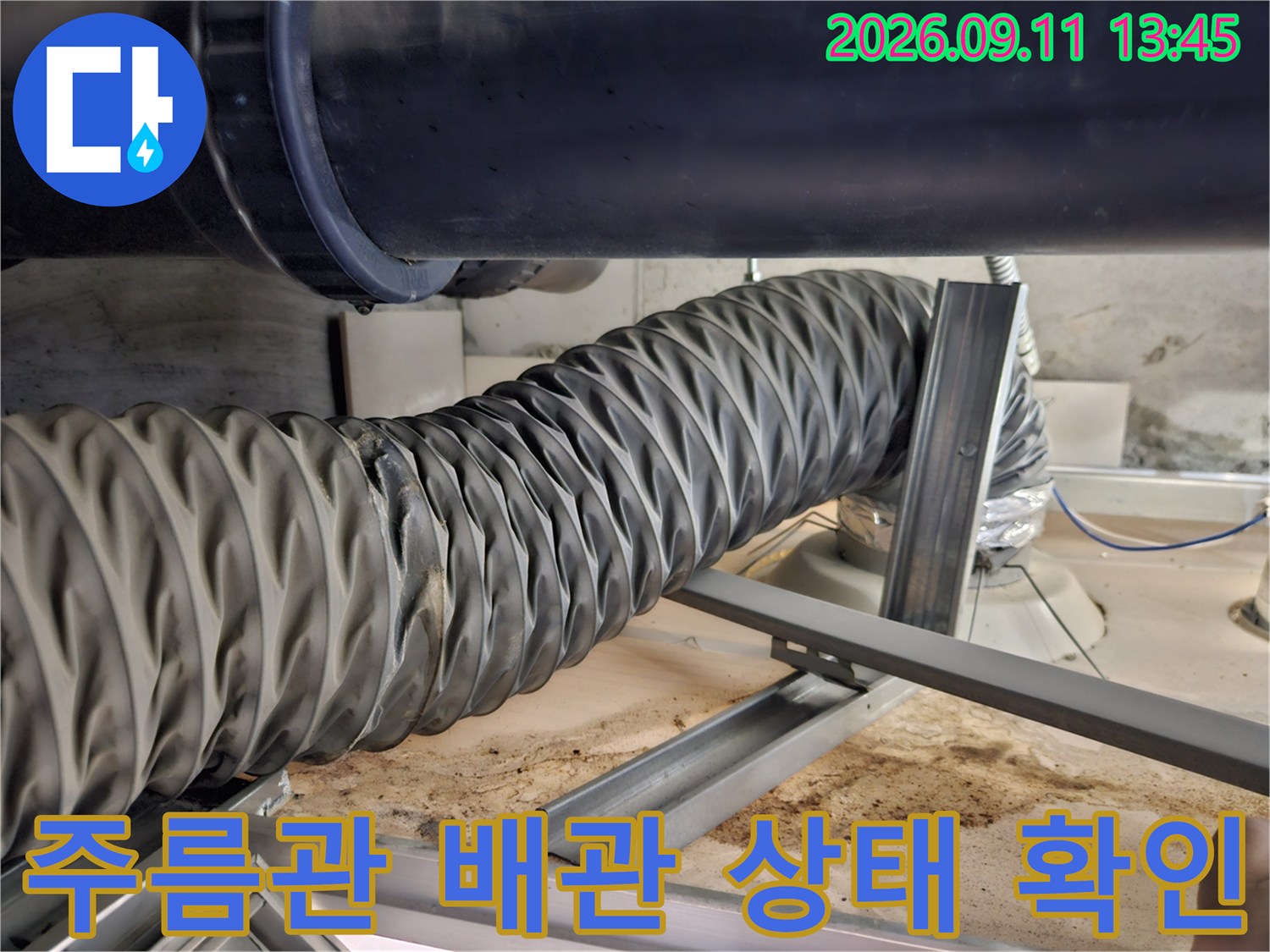 배관 하부에 설치된 유연한 주름관과 금속 지지 프레임 상세