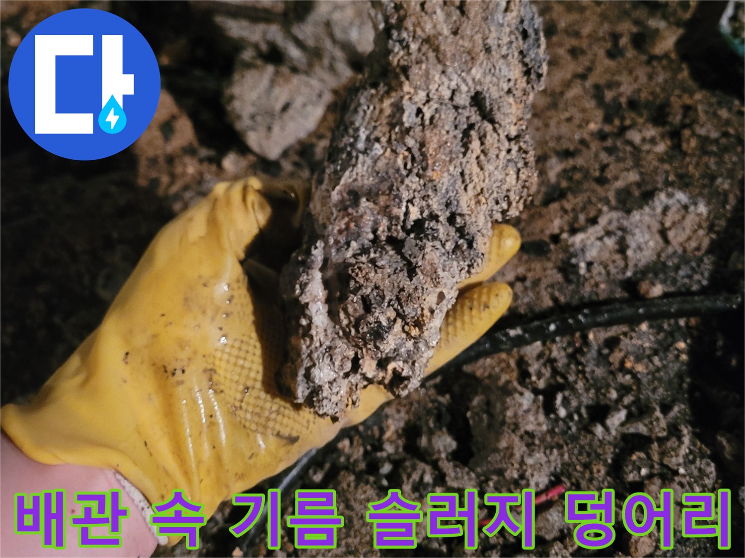 노란색 작업 장갑에 들린 커다란 배관 오염물