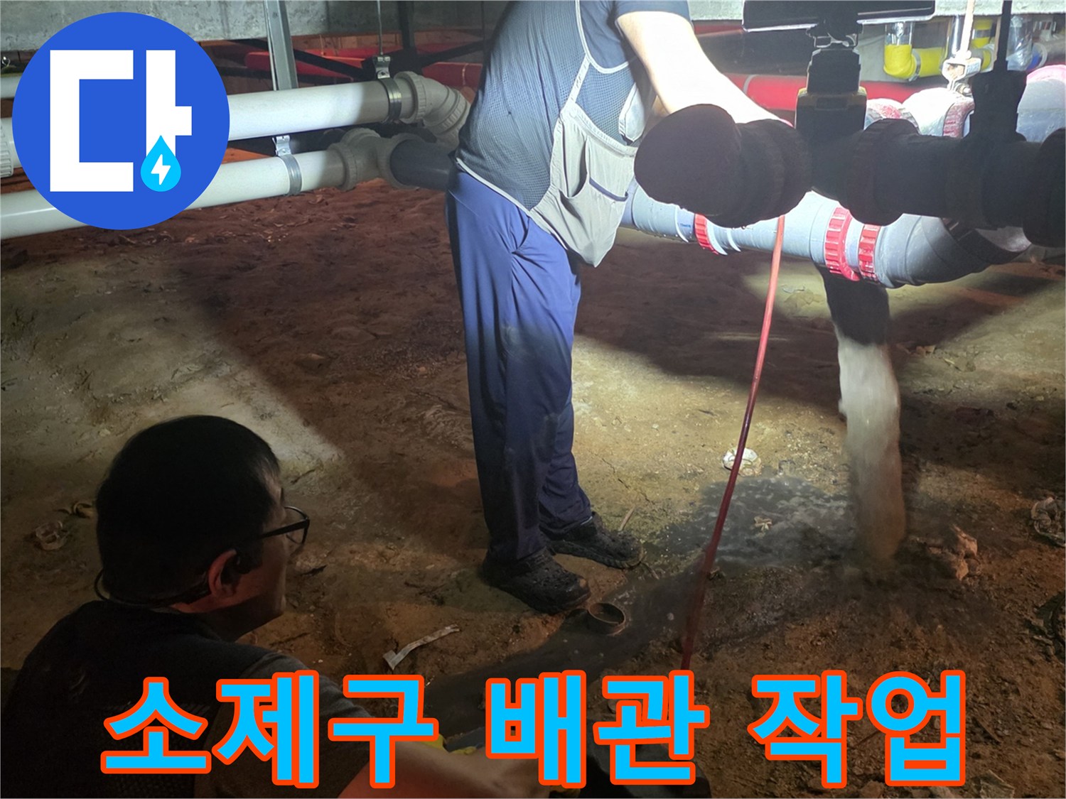 배관 소제구를 열고 내부의 막힘을 해결하기 위해 장비를 운용하는 모습