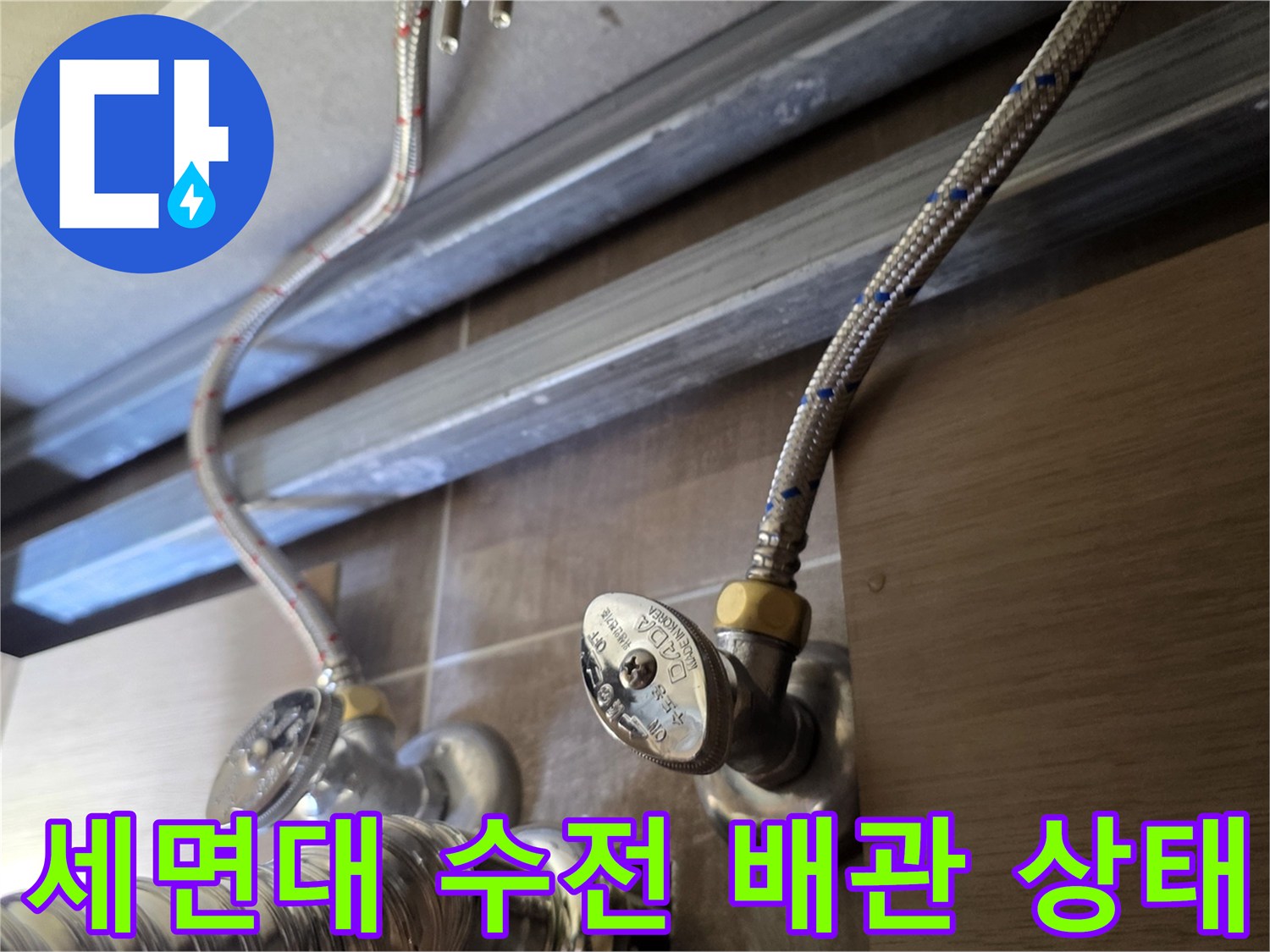 세면대 아래쪽-금속 재질의 급수 호스와 밸브 연결 부위 모습