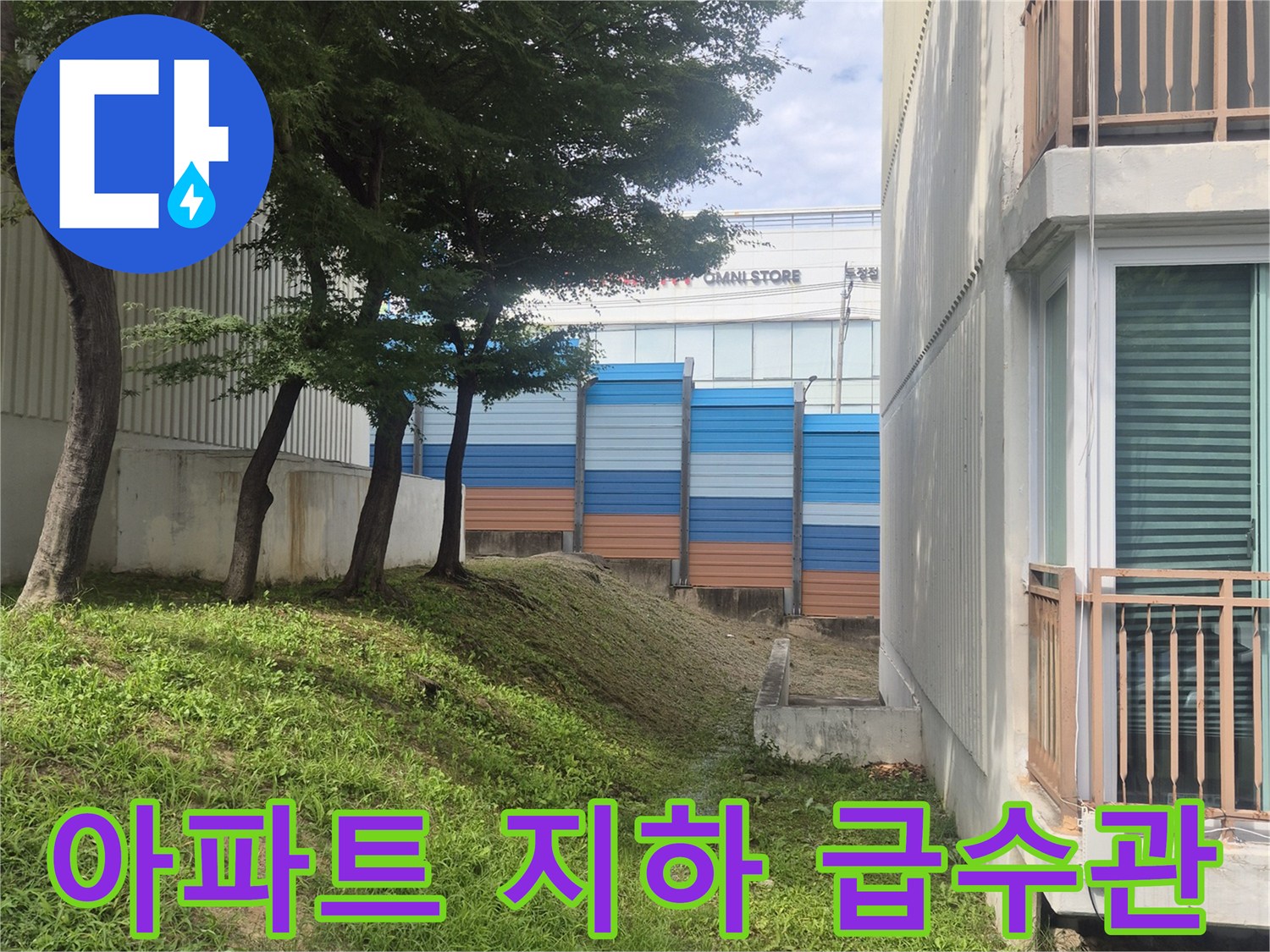 아파트 건물 구조물과 지면 사이에 노출된 푸른색 보온재 배관