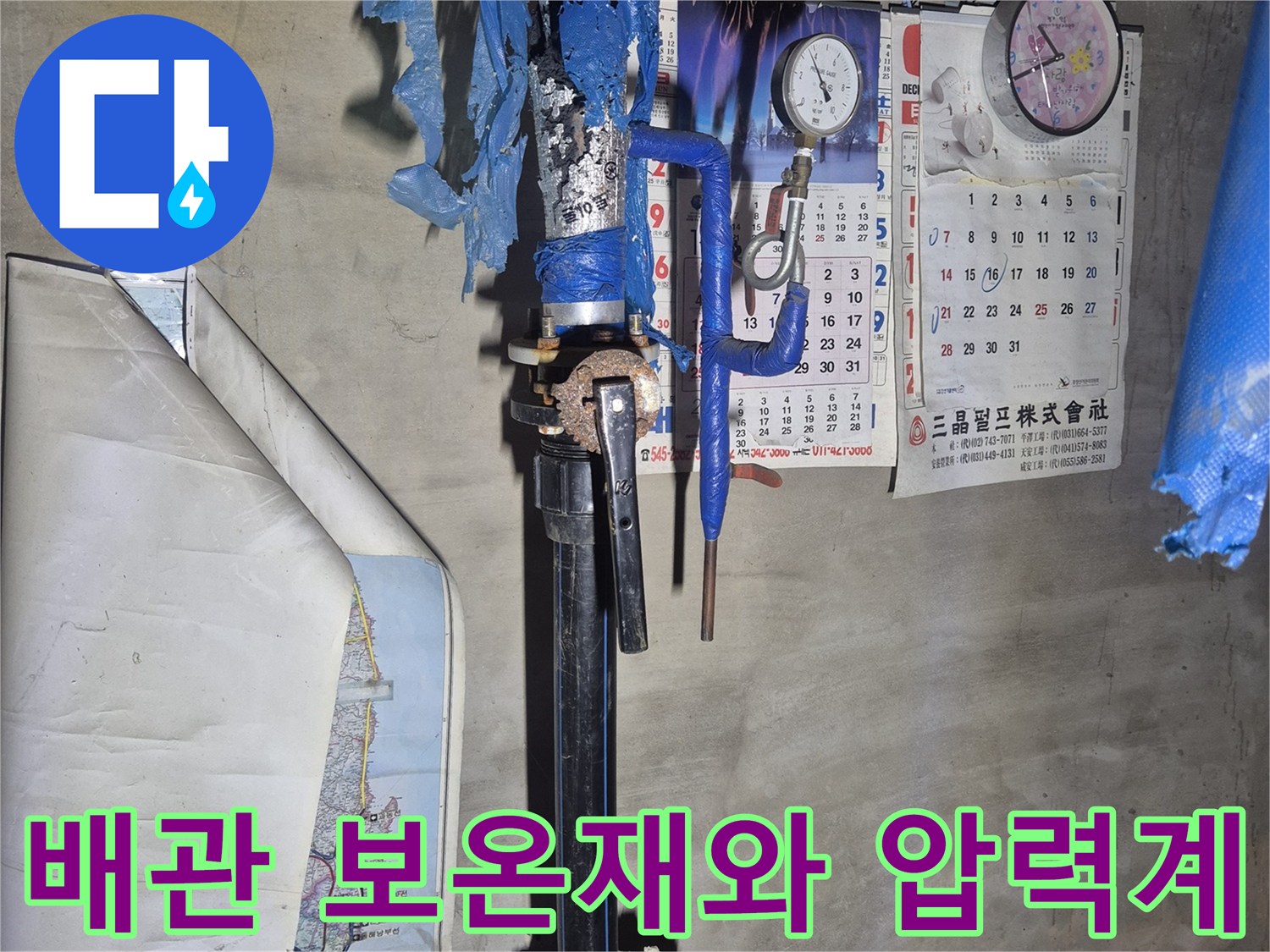 푸른색 보온재가 씌워진 배관과 수압 측정을 위한 게이지 장비