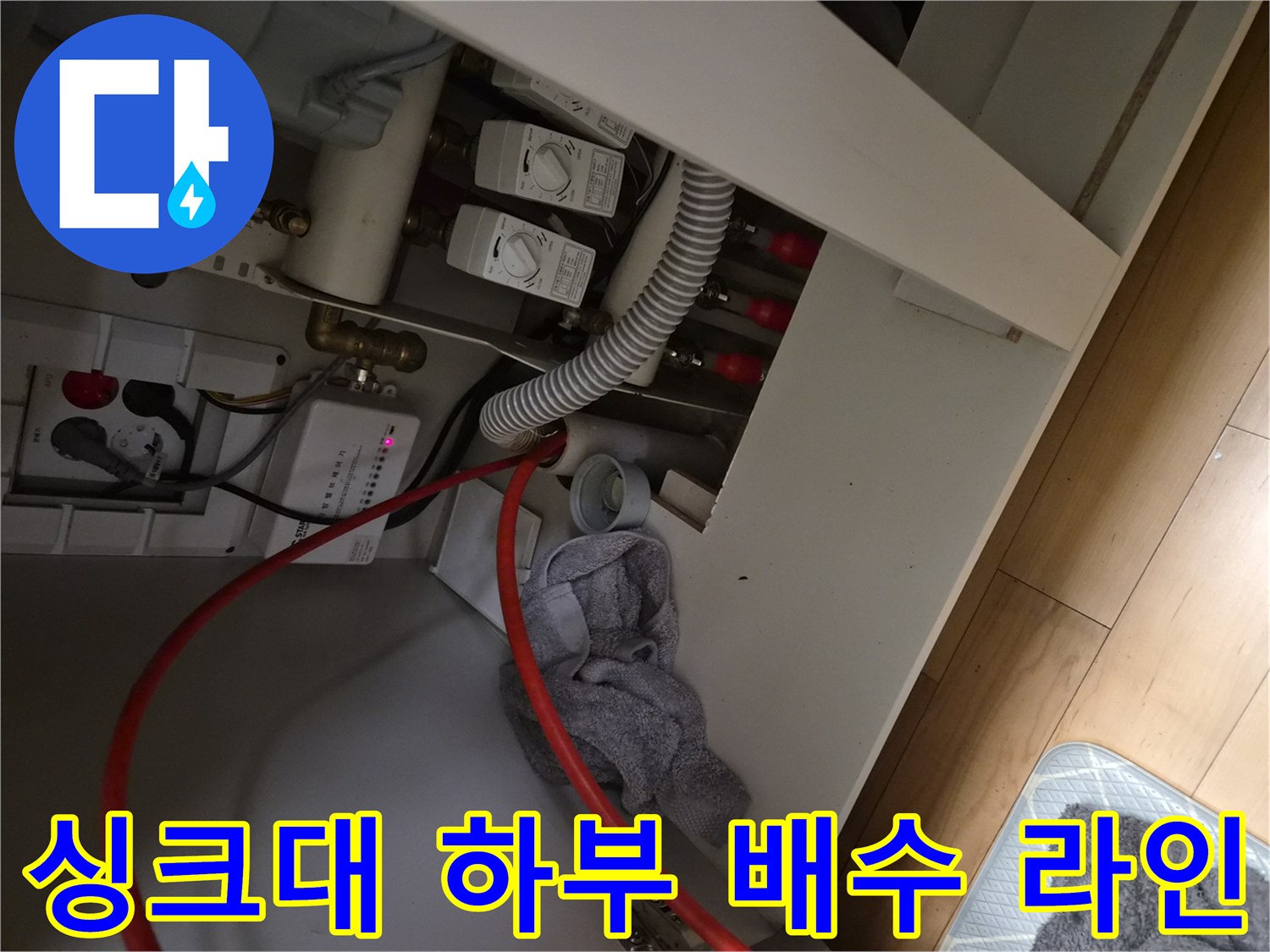 덕양구 동산동 싱크대 하부장의 급수 밸브와 배수 호스 상세 사진