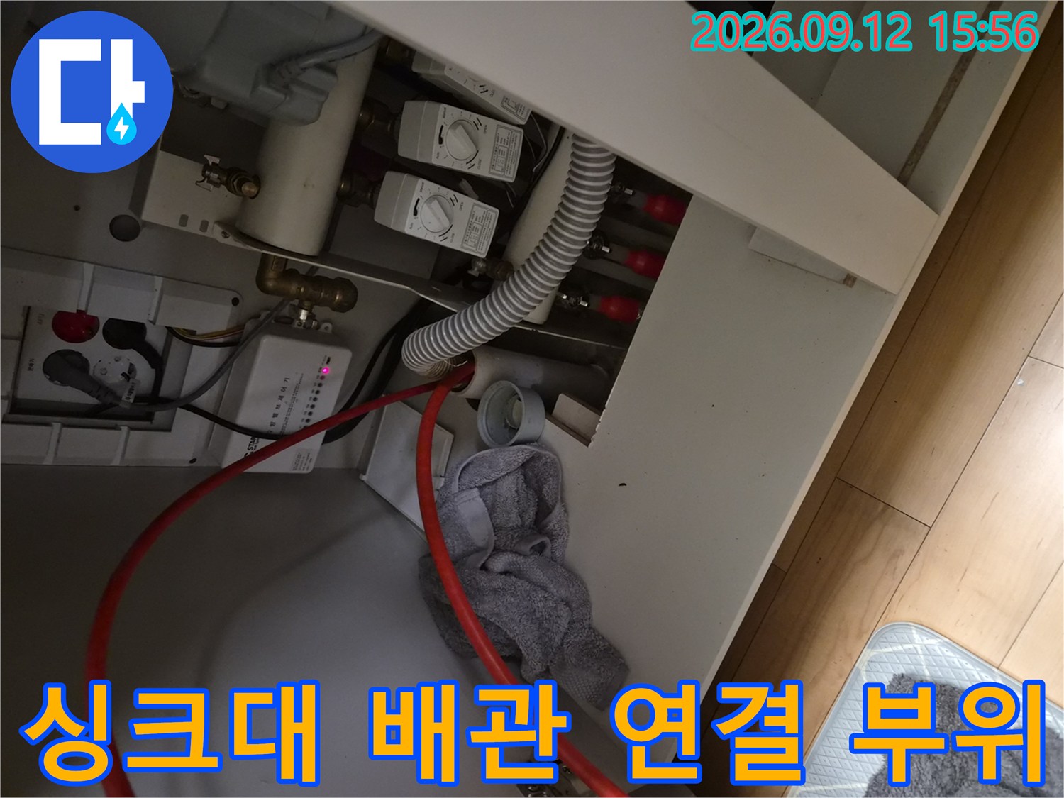 싱크대 하단부의-급수 밸브와 배수 호스가 연결된 내부 모습입니다.