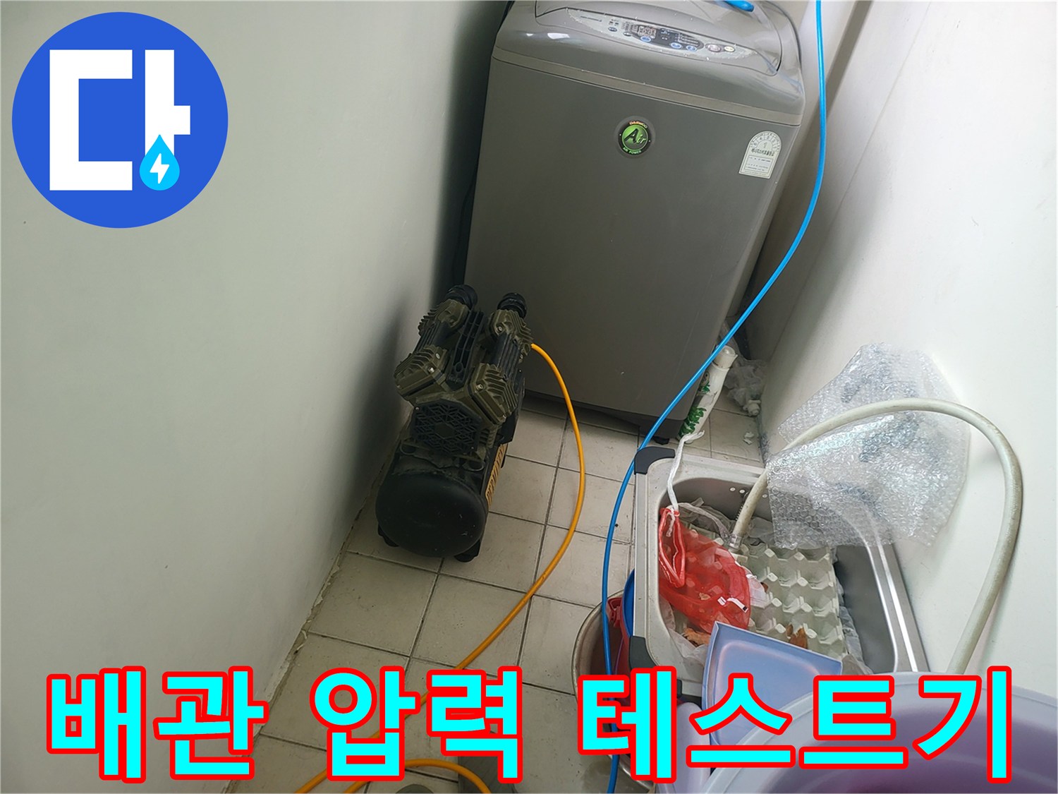 보일러 아래 설치된 공압 장비와 연결된 파란색 호스 상세 컷입니다.