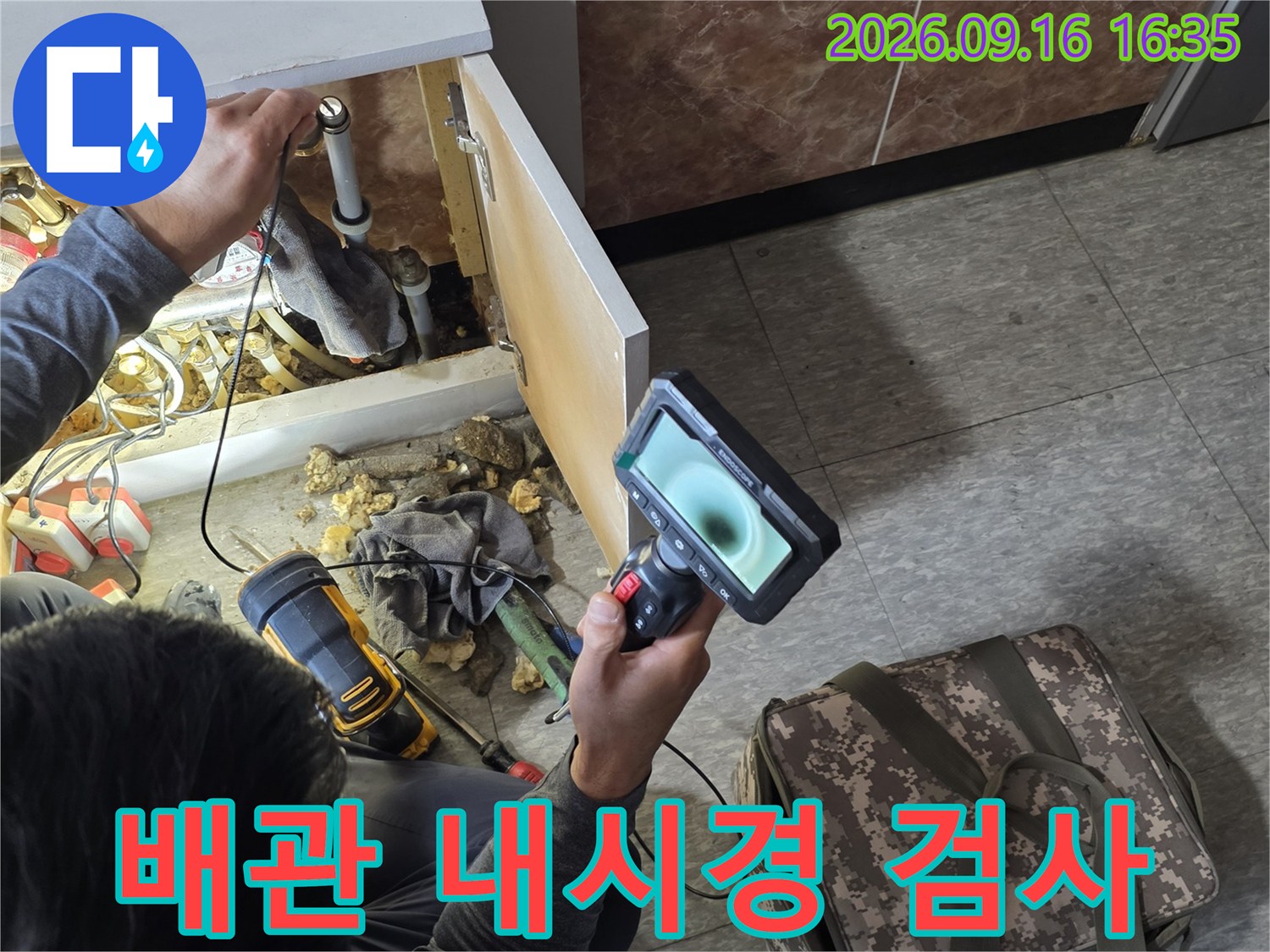 배관 내부 상태를 확인하기 위해-내시경 카메라를 사용하는 모습입니다.